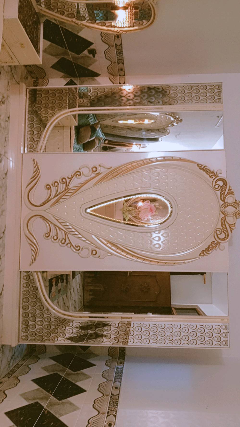 غرفة نوم مميزة بتصميم كلاسيكي فاخر، تتكون من سرير كبير ومريح مع لوح رأس ذو زخارف أنيقة ومرآة رائعة. الطقم يشمل أيضًا خزائن جانبية وتصميم فني على الجدران والخزائن. القطع مصنوعة بعناية لتضيف لمسة من الفخامة لأي غرفة نوم.