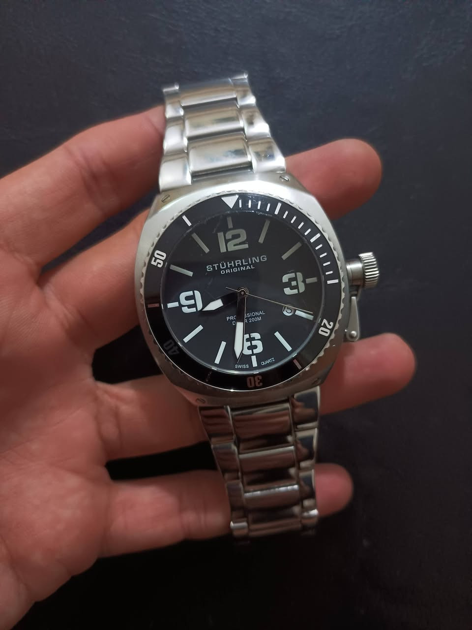 السلام عليكم
...السعر 85...
Stührling Original اصلي 
نوع الحركة: حركة كوارتز سويسرية (Swiss Quartz) لضمان الدقة في ضبط الوقت.
نافذة عرض التاريخ 
مقاومة الماء: تصل إلى 200 متر (660 قدمًا)، وهي مزودة بتاج لولبي لضمان الحماية القصوى ضد تسرب الماء.
المواد: هيكل وسوار من الفولاذ المقاوم للصدأ (Stainless Steel) مع إطار خارجي (Bezel) دوار أحادي الاتجاه.
المينا: أسود مع أرقام عربية كبيرة ومؤشرات مضيئة لسهولة القراءة في الظلام أو تحت الماء.
الزجاج: مصنوع من كريستال Krysterna™، وهو نوع متين


**إذا كنت صاحب هذا الإعلان وتريد حذفه لأي سبب، رجاءا أرسل رسالة إلى الدعم الفني**