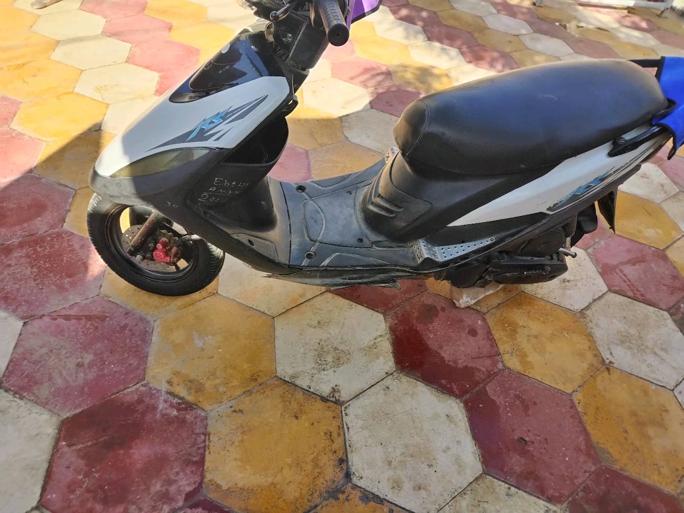 ماكينة ستوتة عملية مع غطاء مقعد، مثالية للحركة السريعة داخل المدينة. اللون الأسود والأبيض يعطيها مظهر أنيق.