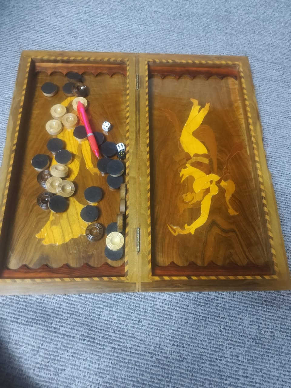 طاولة زهر (Backgammon) خشبية تقليدية مزخرفة بفن "الخاتم" أو "الماركتري" الإيراني، والذي يتضمن تطعيم الخشب بقطع صغيرة من مواد أخرى. السعر 75 الطلب على الواتساب ***********
