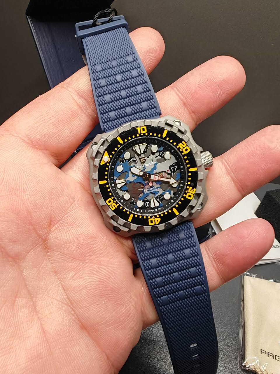 السلام عليكم، ساعة باجاني ديزاين PD-YN009 للرجال، بتصميم عسكري
ساعة باجاني ديزاين PD-YN009 للرجال، بتصميم عسكري مموه، مينا مجوف، قطر 40.7 مم، مقاومة للماء حتى عمق 200 متر، حركة ميكانيكية أوتوماتيكية NH35، زجاج زفير ياقوتي واميال لامينوس مضيء، مناسبة للرياضات والغوص
اللون سلفر تيتانيوم
اسم العلامة التجارية: ساعة باجاني ديزاين
رقم الموديل: باجاني ديزاين PD-YN009
النمط: ساعة أنيقة وعصرية، ساعة رياضية
ميزة: مقاومة للماء، السباحة والغوص 200 متر تحت الماء، عقارب مضيئةم، ضاد للمغناطيسيةم، قاومة للماءت، حديد التاريخ التلقائيم، قاومة للصدمات، حركة أوتوماتيكية ذاتية التعبئة، حركة ميكانيكية يدوية التعبئة، عمق مقاومة الماء: 20 بار
نوع مادة زجاج المينا: كريستال الياقوت (زفير) 
قطر المينا: 43.3 ملم
سُمك العلبة: 13.4 مم
عرض السوار: 22 مم
طول السوار: 24 سم
نوع المشبك: إبزيم
مادة الهيكل: ستانلس ستيل فولاذ المقاوم للصدأ
نوع مادة السوار: ربر مطاط مقاوم للتعرق
يوجد توصيل لجميع المحافظات ***********
