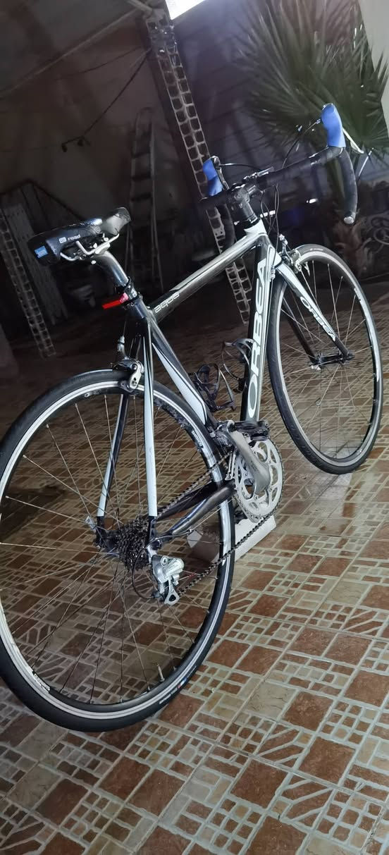 للبيع دراجة طريق (Road Bike) من شركة Orbea الإسبانية العريقة، قطعة مميزة ونادرة جداً. الدراجة هي "رفيقة الدرب" التي بدأت بها مسيرتي في عالم الروود بايك، وهي بحالة ممتازة (نظافة 90-95%)، ومجهزة بكل ما يحتاجه المحترف.
لماذا تقتني هذه الدراجة؟ ببساطة، لأنك تشتري "الأصل". شركة Orbea من الشركات التي لا تقوم بتصنيع نسخ "كوبي" أو "كوبي ماستر" لدراجاتها؛ فكل ما تراه يحمل علامة Orbea هو دراجة أصلية 100%. هذا يضمن لك اقتناء دراجة ذات هندسة وتصنيع أوروبي أصلي، بعيداً عن مخاطر التقليد.

سبب البيع: أنا أبيعها فقط لأنني بصدد الانتقال لمستوى أعلى وتحديث دراجتي إلى موديل أحدث، وتحديداً عيني على فئة (Orbea Orca) التي أطمح للاقتناء منها. الدراجة كانت معي في كل خطوة، وأتمنى أن تذهب لشخص يقدر قيمتها تماماً كما فعلت.

المواصفات التقنية:

الفريم: ألمنيوم خفيف ومتين، قياس (52-53).

الماشة (Fork): كاربون فايبر (لتقليل الوزن وامتصاص الصدمات).

بوري السرج (Seatpost): كاربون.

نظام السرعات: شيمانو تياگرا (Shimano Tiagra)، نظام 9 خلفي و 2 أمامي.

السرج: تم تطويره إلى سرج احترافي من شركة ISM العالمية، مخصص للراحة القصوى في المسافات الطويلة.

الضمان: الدراجة سليمة ومكفولة من أي عيوب أو أعطال في (السيستم أو الفريم)، وأمنح المشتري فترة ضمان لمدة أسبوع للتأكد من سلامة الدراجة وخلوها من أي خلل تقني.

السعر والتواصل:

السعر: 450$ (وبيها مجال بسيط للجادين).

الموقع: ديالى - بعقوبة.

التوصيل: متوفر خدمة توصيل لأي مكان.

للمعاينة أو الشراء، يرجى مراسلتي على الخاص.
او الاتصال على رقمي الشخصي ***********
الدراجة بانتظار مالك جديد يقدر قيمتها الحقيقية!
