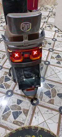 دراجة نارية كهربائية حديثة، بحالة جيدة جداً، لونها رمادي مع تفاصيل برت...