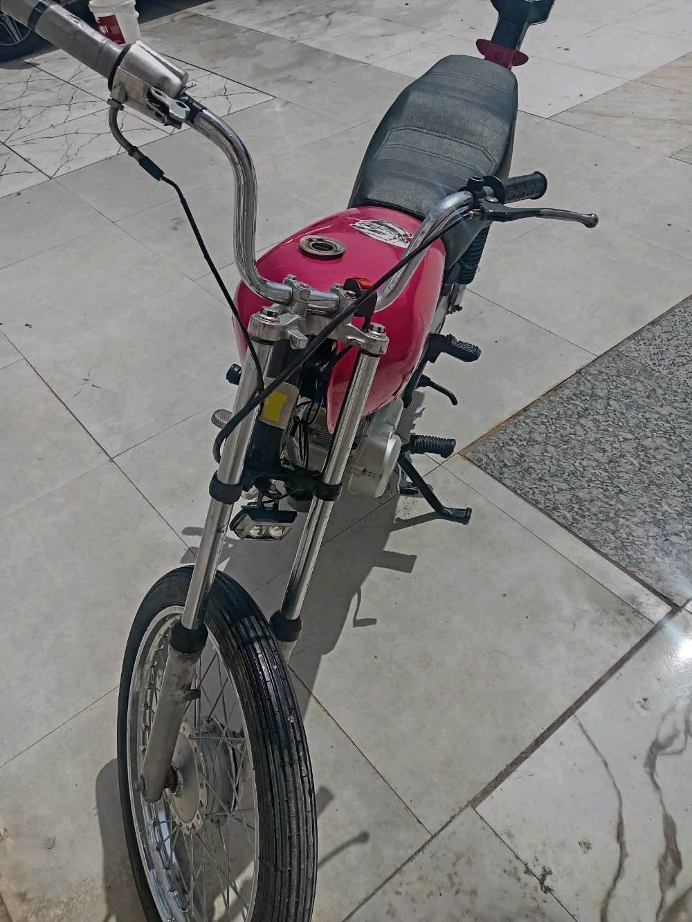 دراجة بخارية رائعة ذات لون وردي لامع ومزينة بكلمة MARDE على الجانبين. الدراجة بحالة جيدة وتعمل بسلاسة، مثالية للتنقل اليومي أو الاستعمال الشخصي. تحتوي على محرك قوي وقدرة تحمل جيدة، مما يجعلها مناسبة لمختلف أنواع الطرقات. شكلها المميز والتفاصيل الجميلة تضيف لمسة من الأناقة والتميز.
