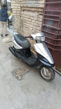 دراجة سكوتر بحالة جيدة مع لونين مميزين، الأسود والفضي. مثالية للتنقل ف...