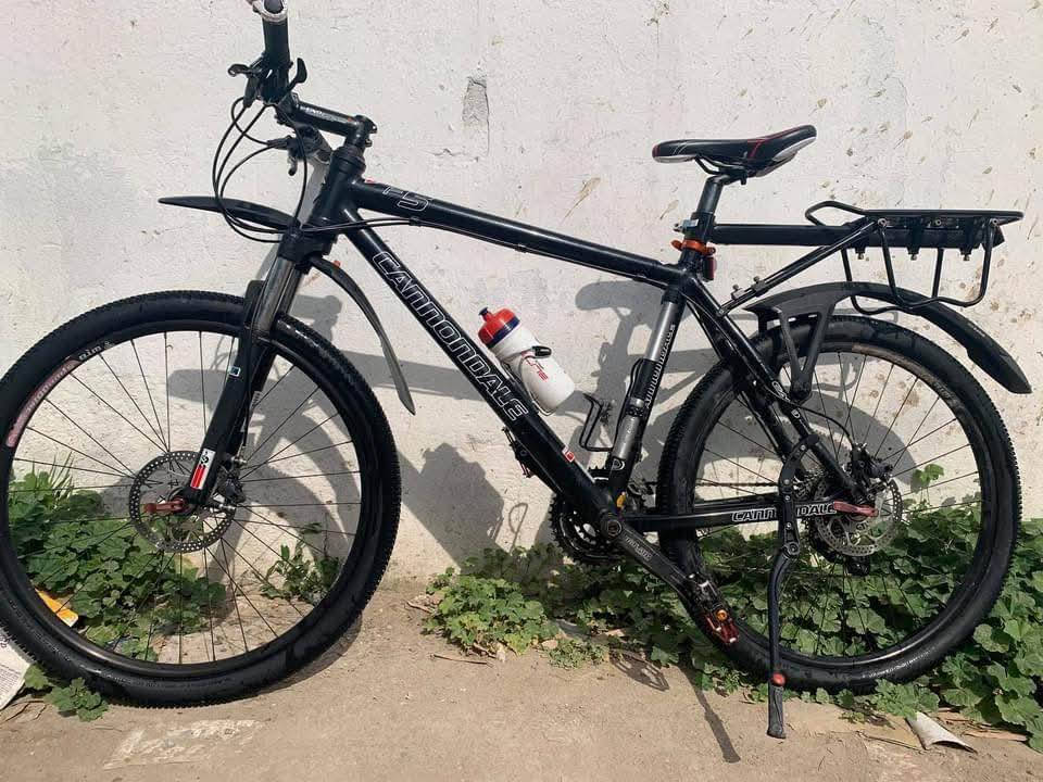 ​الماركة: كانونديل (Cannondale)، وهي علامة تجارية أمريكية رائدة ومعروفة بجودة هياكلها.
الطراز: F5 (سلسلة F)، وهي دراجة جبلية مصممة للأداء الرياضي على الطرق الوعرة واليومية.

​2. الحجم (Size)

​حجم العجلات: يظهر من الصورة "136978.jpg" أن الدراجة تعتمد على عجلات بحجم 26 إنش، وهو الحجم الكلاسيكي لدراجات الجبل التي توفر تحكماً عالياً وسهولة في المناورة.

​حجم الهيكل: الهيكل يبدو من القياسات المتوسطة (Medium)، وهو مناسب للأطوال التي تتراوح غالباً بين 165 سم إلى 178 سم تقريباً.

​3. المواصفات الفنية (Specifications)

​مادة الهيكل: ألمنيوم خفيف الوزن وعالي القوة (تبدو اللحامات واضحة بأسلوب كانونديل المميز).

​نظام التعليق (المساعدات): مساعد أمامي (Front Fork) لامتصاص الصدمات.

​المكابح: ديسك بريك (Disc Brakes) ميكانيكي يوفر أداءً ممتازاً في الأجواء الرطبة والترابية.

​مجموعة السرعات: 

​ناقل حركة خلفي وأمامي متعدد السرعات.

​أذرع التدوير (Cranks) من نوع Truvativ.

​الإطارات: إطارات جبلية بنقشة خشنة لتوفير الثبات على الأراضي الرملية والصخرية.

​الماركة: كانونديل (Cannondale)، وهي علامة تجارية أمريكية رائدة ومعروفة بجودة هياكلها.
السعر ٦٠٠$ الاتصال على الرقم
***********
