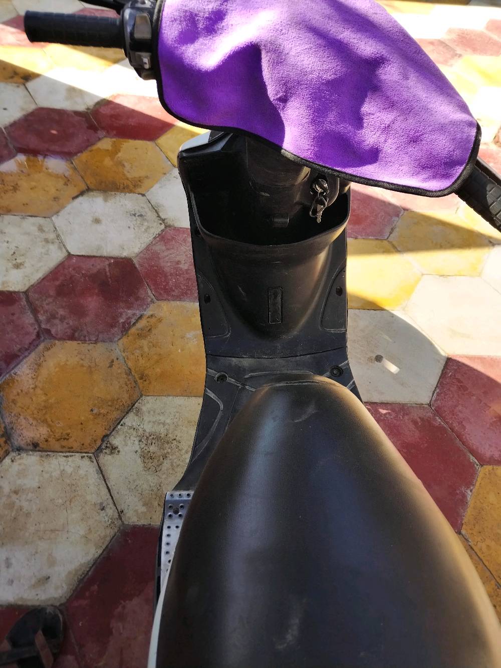 ماكينة ستوتة عملية مع غطاء مقعد، مثالية للحركة السريعة داخل المدينة. اللون الأسود والأبيض يعطيها مظهر أنيق.