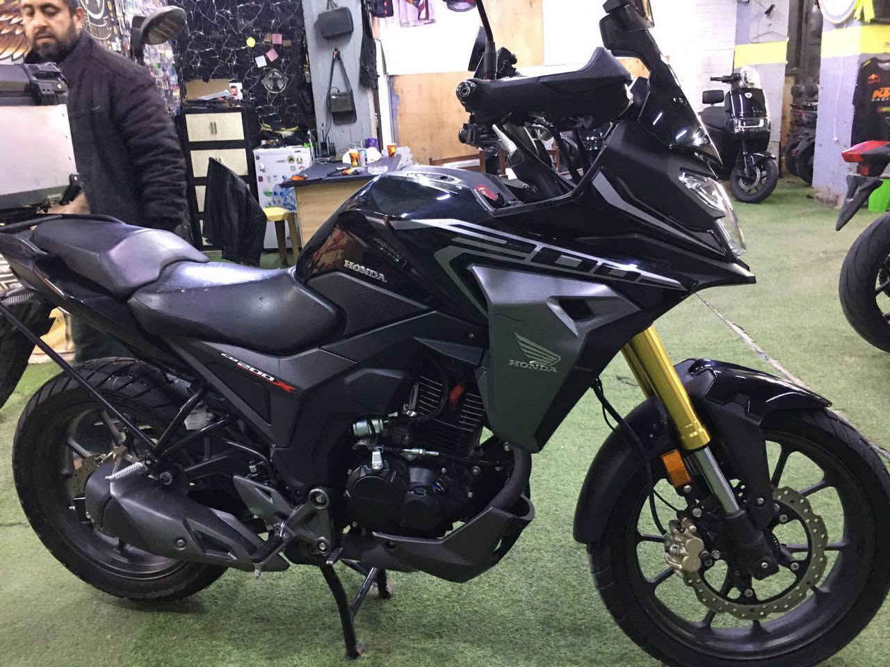 موندا CB200X موديل 2024 تأتي
adventures_center_iraq
بتصميم مستوحى من الدراجات المغامرات (ADV) مع تحديث رئيسي هو إضافة مساعد وقابض انزلاقي (Assist & Slipper Clutch)، بالإضافة إلى إضاءة LED، شاشة LCD رقمية، ومكابح قرصية مع ABS أمامي، وهي مبنية على هيكل Hornet 2.0 وتوفر وضعية قيادة مستقيمة ومريحة للمسافات الطويلة، مع محرك 200cc.
المواصفات الرئيسية:
المحرك: 184.4 سي سي, أحادي الأسطوانة.
القوة: حوالي 17.2 حصان.
عزم الدوران: 16.1 نيوتن متر.
ناقل الحركة: 5 سرعات.
التعليق: شوكة أمامية مقلوبة (USD)، ومونو-شوك خلفي.
المكابح: قرصية مع ABS في الأمام (أحادية القناة).
الوزن: 147 كجم (وزن السير).
الميزات: شاشة LCD رقمية، مصابيح LED.
.(Assist & Slipper Clutch) قابض مساعد ومنزلق :2024 التحديث ل
السعر : $2600 شط العرب, البصرة


**إذا كنت صاحب هذا الإعلان وتريد حذفه لأي سبب، رجاءا أرسل رسالة إلى الدعم الفني**