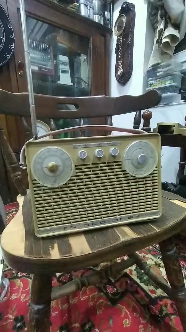 جهاز  راديو ترانزستور كلاسيكي نادر من طراز Piccolone،  من إنتاج شركة SABA الألمانية العريقة (غالباً موديل من أوائل الستينيات). يتميز هذا الراديو بتصميمه الذي يجمع بين البساطة الهندسية والفخامة التقنية لتلك الحقبة.
​إليك التفصيل الفني والجمالي لهذه القطعة:
​ المواصفات التقنية (من الواجهة)
​نظام الترانزستور: مكتوب عليه "10 Transistor"، وهو ما كان يعتبر طفرة تقنية في وقته، حيث تضمن هذه الترانزستورات جودة التقاط عالية وصوت نقي مقارنة بالأجهزة الأقدم.
​الموجات والترددات:
​الميناء الأيسر: مخصص لموجة الـ FM (ترددات من 88 إلى 104 ميجاهرتز).
​الميناء الأيمن: مخصص للموجات الطويلة والمتوسطة (LW/MW).
​أدوات التحكم: يحتوي على ثلاثة مفاتيح في المنتصف:
​AFB VOL: للتحكم في التشغيل ومستوى الصوت.
​TONE: للتحكم في حدة الصوت (Bass/Treble).
​FM-L-M: مفتاح التنقل بين الموجات الثلاث.
​2. التصميم الخارجي
​الهيكل: مصنوع من البلاستيك المقوى (Bakelite أو بلاستيك عالي الجودة) بلون "كريمي" أو بيج فاتح، مع مقبض علوي جلدي مريح للحمل.
​الشبكة الأمامية: صُممت بشكل خطوط عرضية متقطعة تسمح بخروج الصوت بوضوح وتمنحه مظهراً كلاسيكياً (Retro).
​الميناء (Dials): الأقراص الدائرية الكبيرة شفافة مع مؤشرات حمراء دقيقة، وهي علامة مميزة لتصاميم الستينيات الأوروبية.
​ القيمة التاريخية
​علامة SABA الألمانية كانت منافساً قوياً لشركات مثل "تيلفونكن" و"جرونديج"، وتعتبر أجهزتها اليوم من القطع المرغوبة جداً لدى هواة جمع الأنتيك لجودة صناعتها وطول عمرها الافتراضي.
​يُطلق عليه اسم "Super" (مكتوب في الزاوية اليمنى السفلى)، وهي إشارة إلى تقنية "Superheterodyne" في استقبال الإشارات اللاسلكية.
​نصيحة للعناية بالقطعة:
​بما أن الهيكل من البلاستيك القديم، يُفضل تنظيفه بقطعة قماش ناعمة مبللة قليلاً بالماء وتجنب المنظفات الكيميائية القوية التي قد تتسبب في بهتان اللون أو تشقق البلاستيك.


**إذا كنت صاحب هذا الإعلان وتريد حذفه لأي سبب، رجاءا أرسل رسالة إلى الدعم الفني**