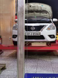 سيارة نيسان صني لونها أبيض، السيارة فيها بعض التعديلات في الجهة اليمنى...