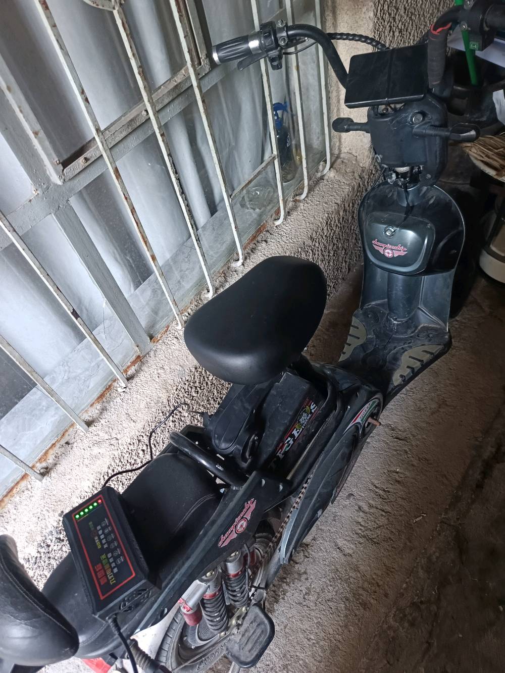 عندي دراجة كهربائية بحالة جيدة، لونها أسود ومجهزة بشاشة عرض صغيرة لعرض معلومات الشحن. مثالية للتنقل داخل المناطق الحضرية. البطارية مشحونة وجاهزة للاستخدام اليومي.
