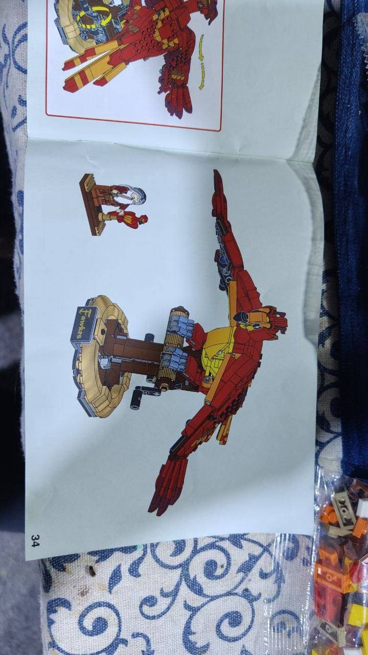 طائر العنقاء "فوكس" (Fawkes)، وهو الطائر الأسطوري المخلص للأستاذ ألبوس دمبلدور في سلسلة أفلام "هاري بوتر".
تفاصيل نموذج "فوكس":
تصميم ميكانيكي: الميزة الأكثر إثارة في هذا النموذج هي وجود مقبض دوار في الخلف (يظهر في الصورة أسفل قاعدة الطائر). عند تدويره، تتحرك الأجنحة للأعلى والأسفل بحركة انسيابية تحاكي طيران العنقاء الحقيقي.
القاعدة: يقف الطائر على قاعدة متينة ومزخرفة تشبه منصة عرض، وعليها لوحة اسم مكتوب عليها "Fawkes".
الألوان: يتميز النموذج بألوانه الزاهية (الأحمر والبرتقالي والأصفر)، تماماً كما وُصف في الأفلام كطائر ناري.
الشخصيات الملحقة: يظهر بجانب النموذج الكبير شخصية "ميني فيجر" (Minifigure) صغيرة للأستاذ ألبوس دمبلدور ومعه نسخة مصغرة جداً من "فوكس".
معلومات سريعة:
عدد القطع: يتكون هذا الطقم عادةً من 597 قطعة.
أبعاد النموذج: يبلغ طول جناحي الطائر عند اكتماله حوالي 35 سم

النسخه مقلدة وليست الاصلية


**إذا كنت صاحب هذا الإعلان وتريد حذفه لأي سبب، رجاءا أرسل رسالة إلى الدعم الفني**