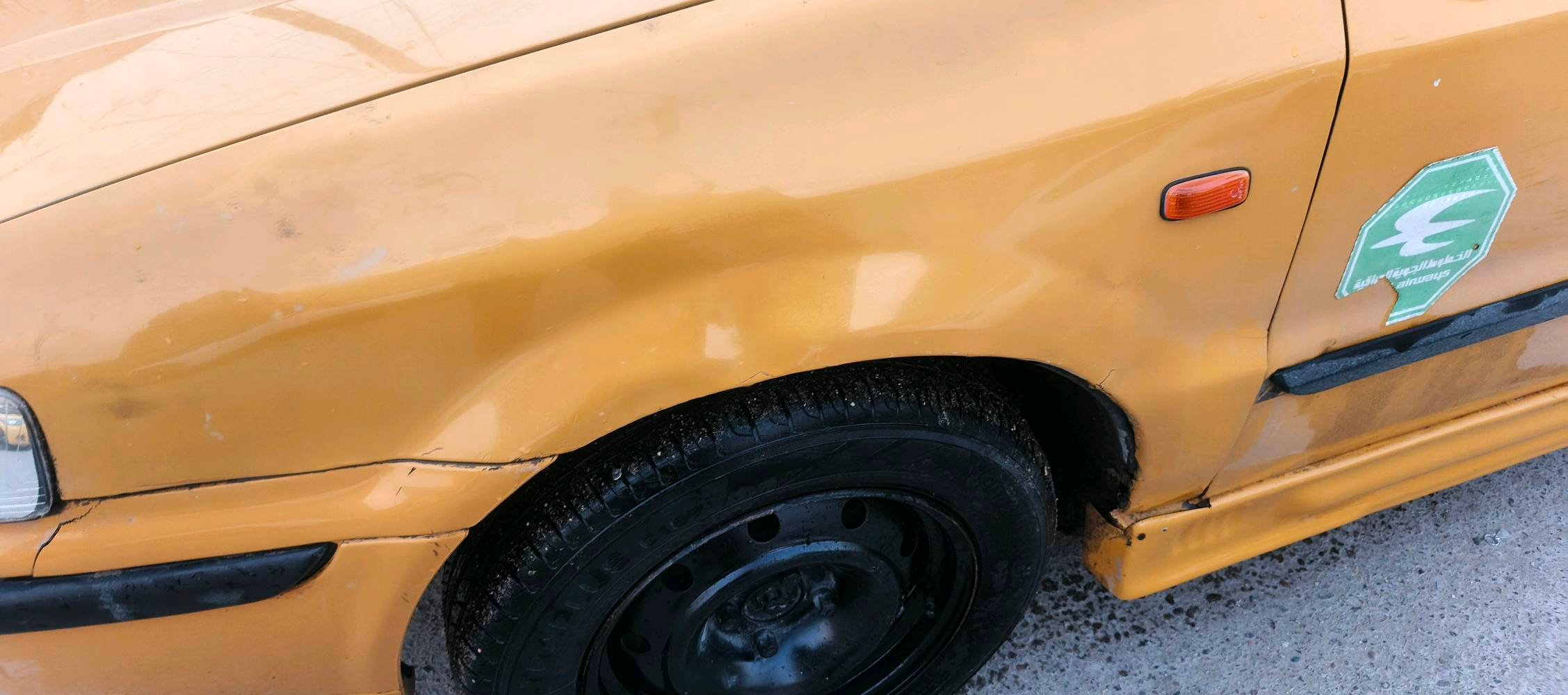 سيارة صالون صفراء، داخلية واسعة وعجلة قيادة مغطاة للراحة. الجنوط باللون الأسود لإضافة لمسة من الأناقة. السيارة مناسبة للاستخدام اليومي. موثوقة للأسر والجولات داخل المدينة.