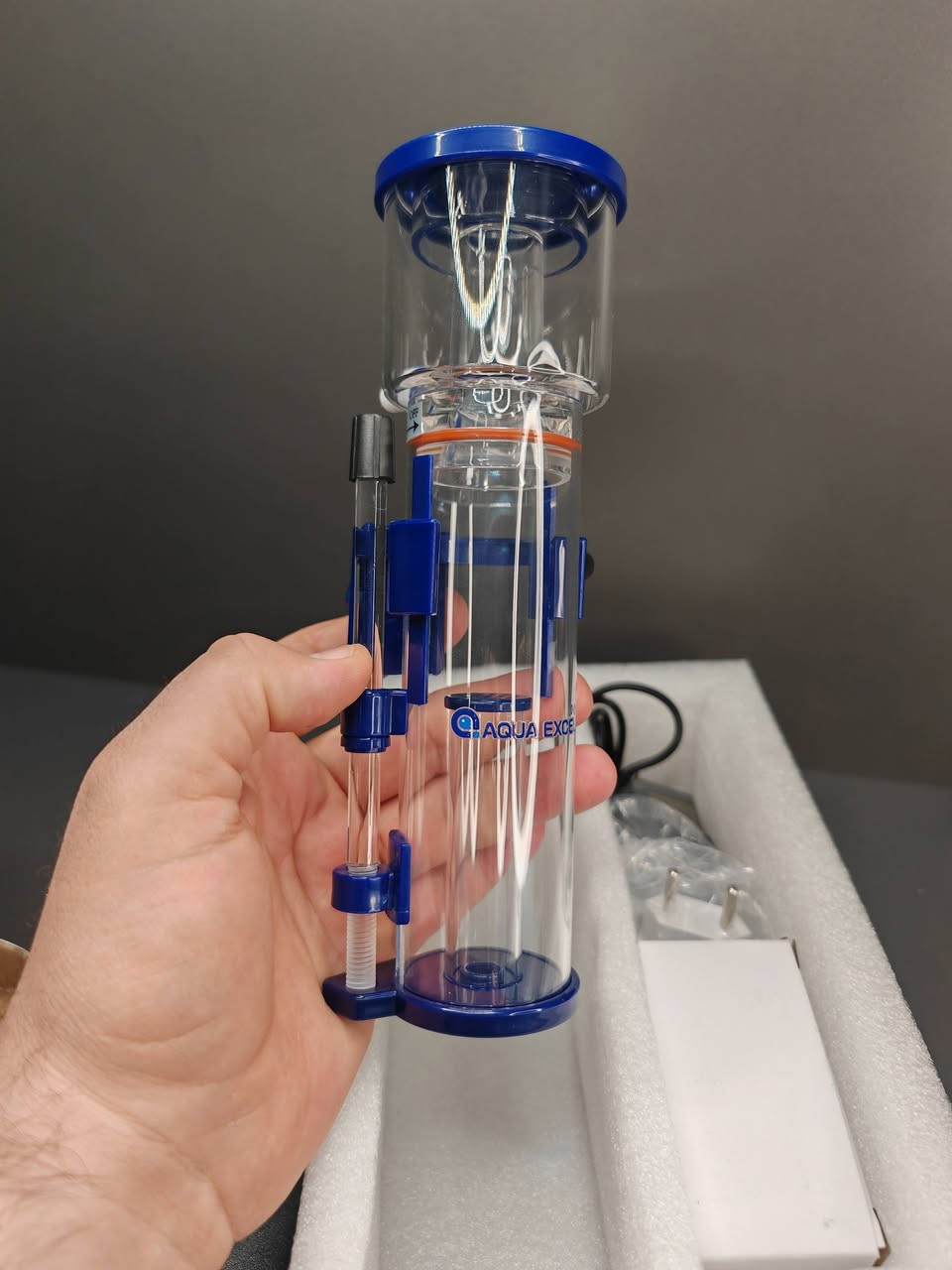 هذا الجهاز هو Protein Skimmer (مقشطة البروتين)، وهو قطعة أساسية ومهمة جداً لأحواض السمك البحرية (المياه المالحة).
إليك شرح مبسط لفائدته وكيفية عمله:
​فائدة الجهاز:
​الوظيفة الأساسية له هي تنظيف المياه من الفضلات العضوية قبل أن تتحلل وتتحول إلى مواد سامة (مثل الأمونيا والنيترات) التي قد تضر الأسماك والمرجان. فهو يعمل كـ "كلية" صناعية للحوض.
​كيفية عمله:
​يعتمد الجهاز على فكرة بسيطة لكنها ذكية جداً:
​خلط الماء بالهواء: يقوم الجهاز بخلط مياه الحوض مع كمية كبيرة من فقاعات الهواء الصغيرة جداً داخل الأنبوب.
​التصاق الأوساخ: الفضلات العضوية والبروتينات الموجودة في الماء تنجذب طبيعياً لفقاعات الهواء وتلتصق بسطحها.
​تكوين الرغوة: ترتفع هذه الفقاعات إلى الأعلى لتشكل رغوة كثيفة (تشبه رغوة الصابون).
​التخلص من الفضلات: تندفع هذه الرغوة إلى الكوب الموجود في أعلى الجهاز (Collection Cup). مع الوقت، تتحول الرغوة إلى سائل داكن اللون وكريه الرائحة يتم تنظيفه يدوياً لاحقاً.
​لماذا هو مهم؟
​صفاء المياه: يساعد في جعل الماء صافياً جداً.
​زيادة الأكسجين: عملية خلط الهواء بالماء تزيد من نسبة الأكسجين المذاب، وهو أمر ضروري لصحة الأسماك.
​تقليل التغييرات المتكررة للماء: لأنه يزيل الفضلات بكفاءة، فإنه يقلل العبء على الفلاتر الأخرى.
​ملاحظة: هذا الموديل الموضح في الصورة (AE-NANO 40D) مصمم خصيصاً للأحواض الصغيرة (Nano Tanks) ويتميز بحجمه المدمج وسهولة تركيبه


**إذا كنت صاحب هذا الإعلان وتريد حذفه لأي سبب، رجاءا أرسل رسالة إلى الدعم الفني**