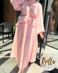 فستان وردي ناعم ورقيق مثالي للمناسبات الخاصة. يتميز بأكمام واسعة وتصمي...