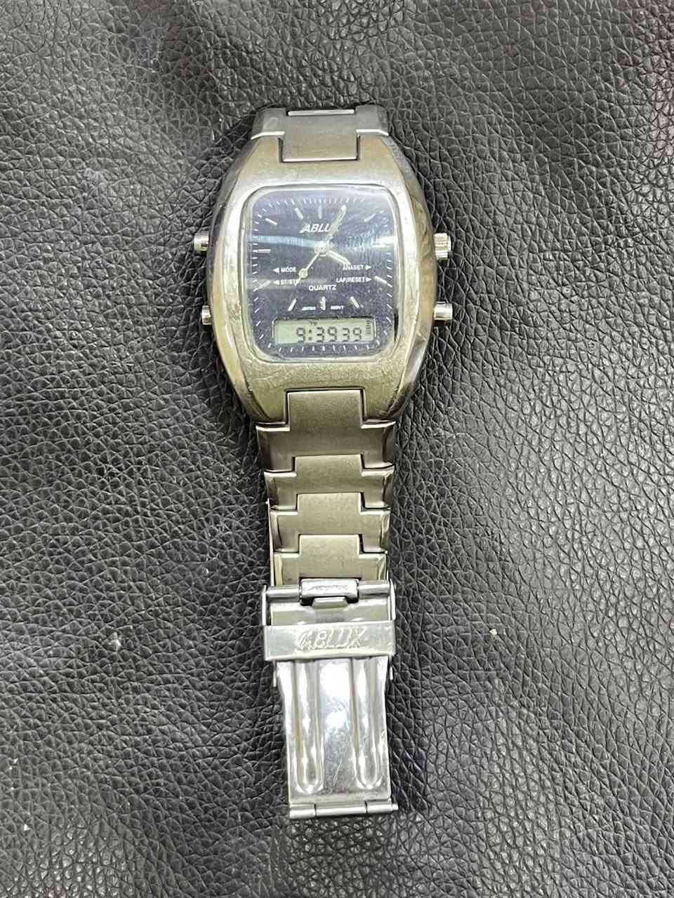 السلام عليكم ساعة يد رجالية بنظام عرض مزدوج (رقمي وتناظري)، وتصميمها يشبه إلى حد كبير ساعات من علامات تجارية مثل Sharp و Perfect. مزدوج (عقارب للوقت التناظري وشاشة LCD للوقت الرقمي). يظهر اسم "ABLU" على الميناء، وهو ما يشير إلى علامة تجارية قد تكون أقل شيوعاً أو مقلدة لتصميمات مشهورة. تعمل بنظام الكوارتز (Quartz) مع حركة يابانية (Japan Movt). مصنوعان من الفولاذ المقاوم للصدأ (Stainless Steel) بلون فضي. تتضمن الساعة أزراراً للتحكم في الأوضاع (Mode)، ضبط الوقت التناظري (Ana Set)، وبدء/إيقاف المؤقت (St/Stop)، وإعادة ضبط الدورات (Lap/Reset). 
التصميم يُعرف بـ "الكرونوغراف الرقمي/التناظري العتيق" (Vintage Dig/Ana Alarm Chronograph). تتميز هذه الساعات بكونها عملية وتجمع بين الشكل الكلاسيكي للعقارب والوظائف الرقمية مثل المنبه وساعة الإيقاف.  السعر ب40مع توصيل


**إذا كنت صاحب هذا الإعلان وتريد حذفه لأي سبب، رجاءا أرسل رسالة إلى الدعم الفني**