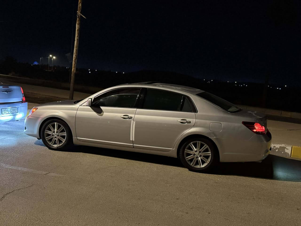 مواصفات تويوتا أفالون 2006 (فئة ليمتد - Limited)
1. الأداء والمحرك:

​المحرك: 6 أسطوانات (V6) سعة 3.5 لتر.

​القوة: 268 حصان.

​ناقل الحركة: أوتوماتيك 5 سرعات (تبديل سلس).

​2. المميزات الخارجية (الخاصة بالليمتد):

​نظام الدخول الذكي: فتح الأبواب وتشغيل السيارة بـ "البصمة".

​الإضاءة: أنوار أمامية زينون (HID) مع حساسات إضاءة تلقائية.

​المرايا: مرايا جانبية مدفأة مع إشارات انعطاف وتعتيم تلقائي.

​الجنوط: ألمنيوم مقاس 17 بوصة بتصميم خاص بالليمتد.

​3. الرفاهية والمقصورة الداخلية:

​المقاعد: جلد فاخر مع خاصية (تبريد وتدفئة) للمقاعد الأمامية.

​الذاكرة: نظام حفظ وضعيات القيادة لمقعد السائق.

​النظام الصوتي: نظام JBL Synthesis الفاخر (12 سماعة).

​التكييف: تحكم مناخي مزدوج ومنفصل (سائق/راكب) مع فتحات خلفية.

​الستارة: ستارة خلفية كهربائية (تنخفض تلقائياً عند الرجوع للخلف).

​التخشيب: لمسات خشبية كاملة على الطبلون وعصا القير والمقود.

​4. أنظمة الأمان:

​نظام الثبات الإلكتروني (VSC).

​فرامل مانعة للانغلاق (ABS) مع توزيع إلكتروني (EBD).

​نظام كامل للوسائد الهوائية (أمامية، جانبية، وللركبة). ضربته صفحه كامله جهه الصدر صبغ بدون داخل الباقي مكفول ياتري جديد تايرات جدد ادامه كامله نوزلات وبلكات حداديه امامي خلفي كامل بيه راجز بس بل تشغيل وتحياتي للجميع للاستفسار *********** السعر 98 وبيه مجال بسيط
