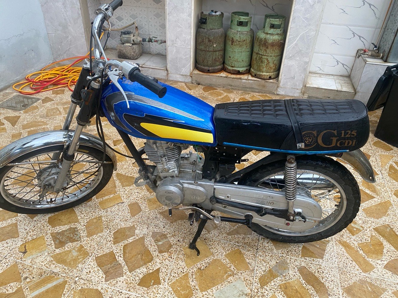 دراجة نارية بحالة جيدة مع محرك CDI ومحرك مُرقم 2014. اللون الأساسي أزرق مع تصميمات صفراء وسوداء على الجسم. مثالية للتنقل اليومي أو الرحلات القصيرة. تعمل بكفاءة وقوية في الأداء.
