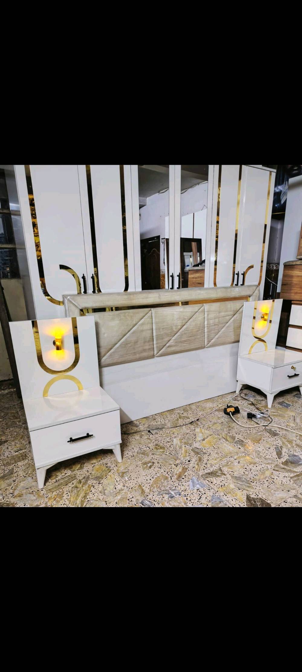 غرفة نوم فخمة للبيع بحالة ممتازة، تتضمن تسريحة بتصميم كلاسيكي مع مرآة كبيرة وأدراج تخزين، سرير مريح بتنجيد فاخر باللون الأزرق الداكن، خزانة راقية بتفاصيل ذهبية، وكمودينات جانبية. التصميم يضيف لمسة من الجمال الكلاسيكي لأي غرفة.