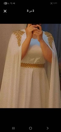 قفطان أبيض ملكي طويل، يتميز بتطريز يدوي ذهبي "شك خرز" على الأكتاف بأسل...