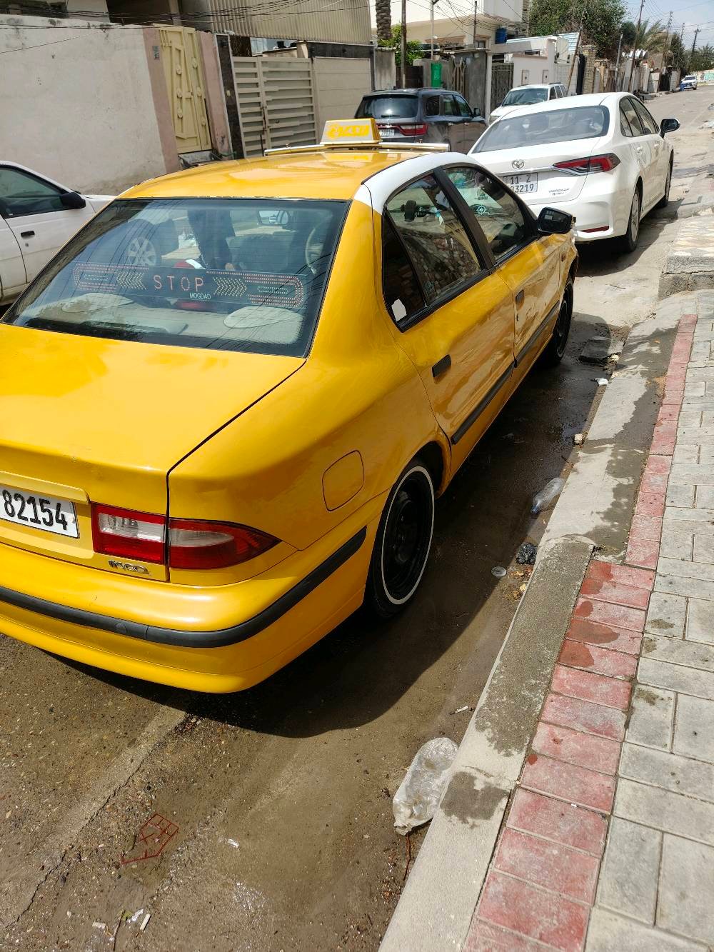 سيارة تاكسي صفراء معروضة للبيع، بحالة جيدة ومستعدة للعمل مباشرة. جسم السيارة نظيف ومصبوغ باللون الأصفر اللامع لتكون مرئية وواضحة في الشوارع.
