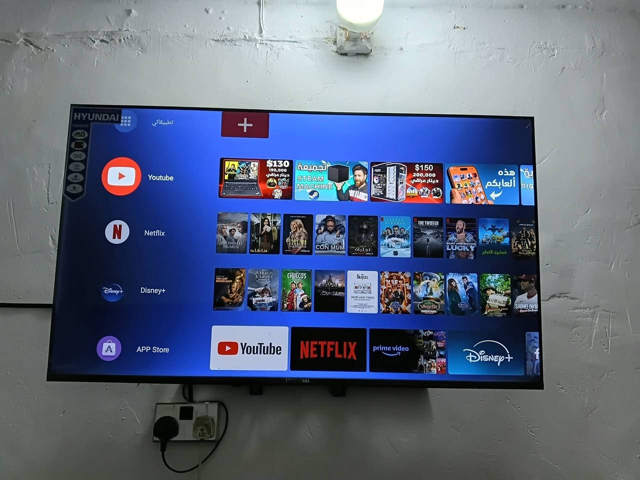هذه الشاشة هي من نوع هيونداي (Hyundai)، وتعمل بنظام تشغيل ذكي (Smart TV) يتيح لك تشغيل تطبيقات البث ومشاركة محتوى الإنترنت.
إليك أهم ما يظهر بخصوص مواصفاتها من الصورة:
​النظام والواجهة: تدعم اللغة العربية وتحتوي على متجر تطبيقات خاص بها لخدمات البث المعروفة.
​التطبيقات المثبتة: يتوفر عليها بشكل مسبق تطبيقات أساسية مثل:
​يوتيوب (YouTube)   ***********
​نتفليكس (Netflix)
​ديزني بلس (+Disney)
​أمازون برايم فيديو (Prime Video)
​متجر تطبيقات (App Store) لتنزيل برامج إضافية.
​إذا كنت تبحث عن رقم الموديل الدقيق (الرمز الخاص بالشاشة)، فغالباً ستجده مطبوعاً على ملصق أبيض أو أسود خلف الشاشة نفسها، ويحتوي على أحرف وأرقام تحدد حجم الشاشة وسنة تصنيعها بدقة.
هذه الشاشة هي من نوع هيونداي (Hyundai)، وتعمل بنظام تشغيل ذكي (Smart TV) يتيح لك تشغيل تطبيقات البث ومشاركة محتوى الإنترنت.
