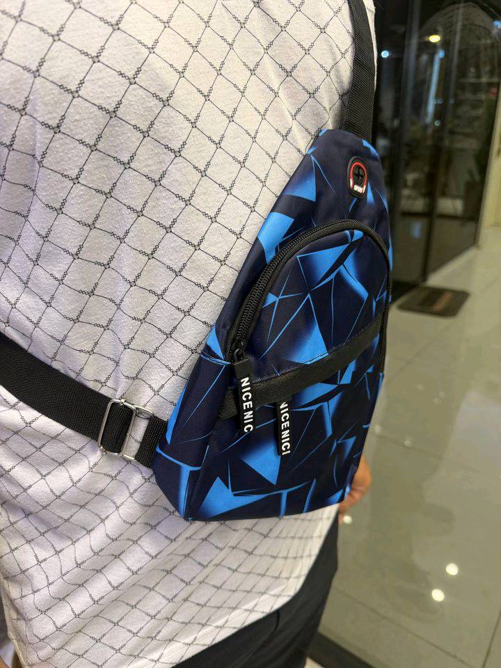 .حقيبة كتف كروس (Sling Bag) عصرية بتصميم شبابي أنيق، مثالية للاستخدام اليومي، السفر، الجامعة أو المشاوير. تتميز بحجم عملي يوفر مساحة كافية 

المميزات:

. تصميم عصري بلون أسود مع نقشة حمراء وزرقاء مميزة.

. خامة متينة ومقاومة للاستخدام اليومي.

. جيب رئيسي واسع مع جيب أمامي بسحاب لتنظيم الأغراض.

. حزام كتف قابل للتعديل ليناسب الجميع.

. خفيفة الوزن ومريحة بالحمل طوال اليوم.

. مناسبة لحمل الهاتف، المحفظة، المفاتيح، الشاحن، وسماعات الأذن.

. سحابات قوية وسهلة الفتح والإغلاق.

. مناسبة للشباب والرجال للاستخدام اليومي والسفر والتنقل