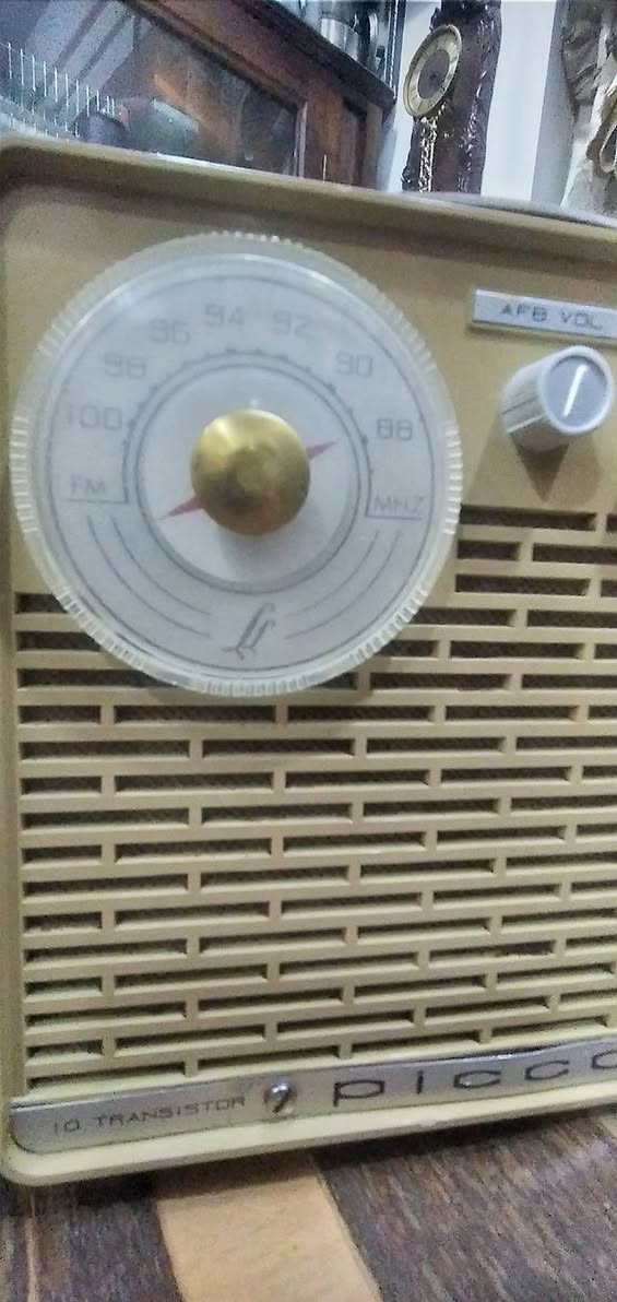 جهاز  راديو ترانزستور كلاسيكي نادر من طراز Piccolone،  من إنتاج شركة SABA الألمانية العريقة (غالباً موديل من أوائل الستينيات). يتميز هذا الراديو بتصميمه الذي يجمع بين البساطة الهندسية والفخامة التقنية لتلك الحقبة.
​إليك التفصيل الفني والجمالي لهذه القطعة:
​ المواصفات التقنية (من الواجهة)
​نظام الترانزستور: مكتوب عليه "10 Transistor"، وهو ما كان يعتبر طفرة تقنية في وقته، حيث تضمن هذه الترانزستورات جودة التقاط عالية وصوت نقي مقارنة بالأجهزة الأقدم.
​الموجات والترددات:
​الميناء الأيسر: مخصص لموجة الـ FM (ترددات من 88 إلى 104 ميجاهرتز).
​الميناء الأيمن: مخصص للموجات الطويلة والمتوسطة (LW/MW).
​أدوات التحكم: يحتوي على ثلاثة مفاتيح في المنتصف:
​AFB VOL: للتحكم في التشغيل ومستوى الصوت.
​TONE: للتحكم في حدة الصوت (Bass/Treble).
​FM-L-M: مفتاح التنقل بين الموجات الثلاث.
​2. التصميم الخارجي
​الهيكل: مصنوع من البلاستيك المقوى (Bakelite أو بلاستيك عالي الجودة) بلون "كريمي" أو بيج فاتح، مع مقبض علوي جلدي مريح للحمل.
​الشبكة الأمامية: صُممت بشكل خطوط عرضية متقطعة تسمح بخروج الصوت بوضوح وتمنحه مظهراً كلاسيكياً (Retro).
​الميناء (Dials): الأقراص الدائرية الكبيرة شفافة مع مؤشرات حمراء دقيقة، وهي علامة مميزة لتصاميم الستينيات الأوروبية.
​ القيمة التاريخية
​علامة SABA الألمانية كانت منافساً قوياً لشركات مثل "تيلفونكن" و"جرونديج"، وتعتبر أجهزتها اليوم من القطع المرغوبة جداً لدى هواة جمع الأنتيك لجودة صناعتها وطول عمرها الافتراضي.
​يُطلق عليه اسم "Super" (مكتوب في الزاوية اليمنى السفلى)، وهي إشارة إلى تقنية "Superheterodyne" في استقبال الإشارات اللاسلكية.
​نصيحة للعناية بالقطعة:
​بما أن الهيكل من البلاستيك القديم، يُفضل تنظيفه بقطعة قماش ناعمة مبللة قليلاً بالماء وتجنب المنظفات الكيميائية القوية التي قد تتسبب في بهتان اللون أو تشقق البلاستيك.


**إذا كنت صاحب هذا الإعلان وتريد حذفه لأي سبب، رجاءا أرسل رسالة إلى الدعم الفني**