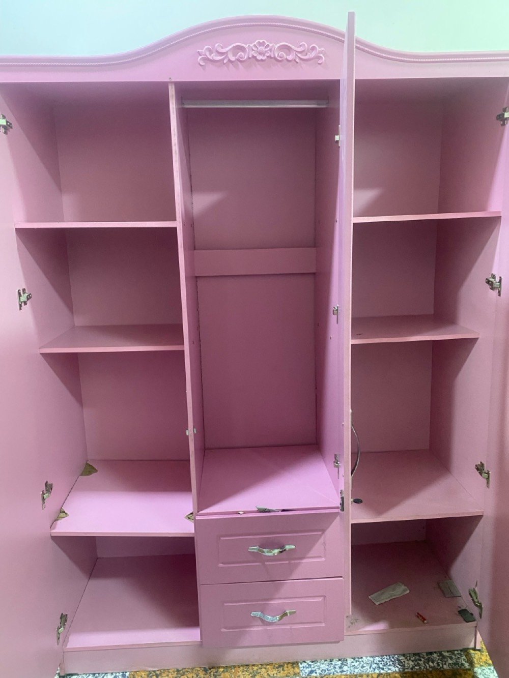كنتور لون وردي مميز وجميل بحالة جيدة جداً. فيه ٣ أبواب مع مرآة في الوسط، ومزخرف بنقوش كلاسيكية رائعة. يحتوي على عدة رفوف داخلية ومساحة لتعليق الأغراض. مثالي لتنظيم ملابسك بشكل أنيق.