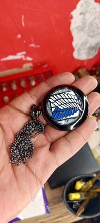 ساعة جيب أنيقة بتصميم أنمي مميز. تحتوي على شعار جذاب من الخارج ووجه أب...