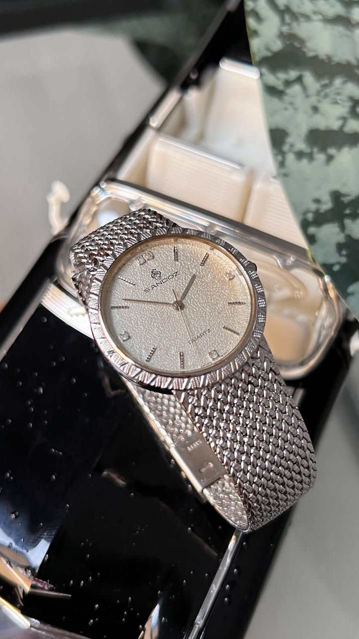 Sandoz
(ساندوز) - ماركة سويسرية غنية عن التعريف.
• الحركة: Quartz (كوارتز) دقيقة جداً.
• القطر: 32 مم (حجم مثالي، انسيابي ومريح جداً على المعصم).
• الميناء (Dial): يتميز بملمس "حبيبي" (Textured) بلون كريمي/فضي يضفي عمقاً وفخامة، مع فصوص أنيقة عند علامات الساعة.
• الإطار (Bezel): إطار مشغول بنقشة هندسية مميزة تعكس الضوء بجمالية عالية.
• السوار (Strap): سوار معدني بنقشة "Mesh" (حصير) ناعمة جداً ومرنة، توفر راحة تامة أثناء الارتداء.
• الظهر: ستانلس ستيل محفور عليه شعار الشركة ورقم الموديل (BM-1020).
• الحالة: الساعة بحالة ممتازة كما هو واضح في الصور، وتعمل بكفاءة تامة.
🔸للأستفسار أكثر يرجى التواصل خاص🔻


**إذا كنت صاحب هذا الإعلان وتريد حذفه لأي سبب، رجاءا أرسل رسالة إلى الدعم الفني**