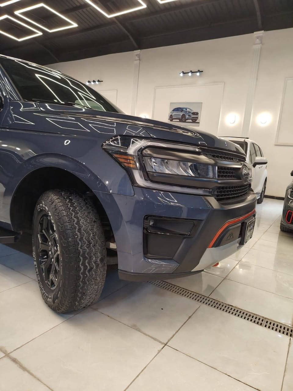 تعتبر فئة تيمبرلاين (Timberline) هي النسخة المخصصة للطرق الوعرة (Off-Road) من فورد إكسبدشن، وتتميز بمزيج بين القوة الهائلة للمحرك والجهوزية العالية للتضاريس الصعبة.
من معرض بلاتينيوم لتجارة السيارات اقدم لكم تحفة خليجيه وكالة القاصد تحت الضمان
فورد اكسبديشن ٢٠٢٣ البترة بسعر مغري
مغلفه ppf 
ممشى ٣٩٠٠٠ فئة تمبر لاين اوف رود من النسخ النادرة 
​المحرك: 6 سلندر (V6) سعة 3.5 لتر ذو شاحن توربيني مزدوج (EcoBoost)، وهو من فئة High-Output عالية الأداء.
​القوة والعزم: يولد قوة 440 حصان وعزم دوران 705 نيوتن متر (أقوى من الفئات القياسية).
​ناقل الحركة: أوتوماتيكي من 10 سرعات (SelectShift).
​نظام الدفع: دفع رباعي (4WD) مع علبة تحويل بسرعتين (دبل خفيف وثقيل) ونظام تفاضل خلفي إلكتروني محدود الانزلاق (eLSD).
​التجهيزات الخاصة بالطرق الوعرة
​الارتفاع عن الأرض: نظام تعليق مرتفع وخاص بالطرق الوعرة يمنح السيارة خلوصاً أرضياً مميزاً (حوالي 10.6 إنش).
​الإطارات والعجلات: جنوط ألمنيوم قياس 18 إنش بلون أسود داكن (Ebony Black)، مجهزة بإطارات "جودير رانجلر" مقاس 33 إنش مخصصة لجميع التضاريس.
​الحماية السفلية: ألواح حماية سفلية (Skid Plates) متينة مستوحاة من فورد رابتر لحماية المحرك وأجزاء السيارة السفلى. فولاذ
​الأنظمة المساعدة: نظام إدارة التضاريس بـ 7 وضعيات قيادة، ونظام Trail Turn Assist للمساعدة في الالتفاف الضيق بالبر.
​التصميم الخارجي والداخلي
​اللمسات الخارجية: تتميز بشبك أمامي أسود فريد، وهوك سحب بلون برتقالي مميز (Active Orange)، مع إضاءة LED كاملة.
​المقصورة: تتسع لـ 7 أو 8 ركاب، وتأتي بمقاعد جلدية (أو مخمل فاخر مخصص) مع تطريزات باللون البرتقالي.
​التبريد (مهم للخليجي): مكيف هواء أوتوماتيكي ثلاثي المناطق عالي الكفاءة يغطي الصفوف الثلاثة، بالإضافة إلى توفر ثلاجة وسيطة في الكونسول الوسطي.
​التقنيات والأمان
​الشاشات: شاشة ترفيه وسطية ضخمة تعمل باللمس قياس 12 إنش (أو 15.5 إنش في الفئات الأعلى الفاخرة) بنظام SYNC 4، مع شاشة عدادات رقمية بالكامل.
​النظام الصوتي: نظام فاخر من Bang & Olufsen (B&O).
​السلامة: نظام كشف النقاط العمياء مع دعم المقطورة، رادار ومثبت سرعة متكيف، كاميرات محيطية 360 درجة، ونظام المحافظة على المسار.
تعتبر فئة تيمبرلاين (Timberline) هي النسخة المخصصة للطرق الوعرة (Off-Road) من فورد إكسبدشن، وتتميز بمزيج بين القوة الهائلة للمحرك والجهوزية العالية للتضاريس الصعبة.
بصمه وتشغيل عن بعد 
كشنات ميموري
١٢ منفذ شحن ٨ راكب 
للاستفسار 
*********** سيف الحسني
لمعرفة السعر اكتب تم

