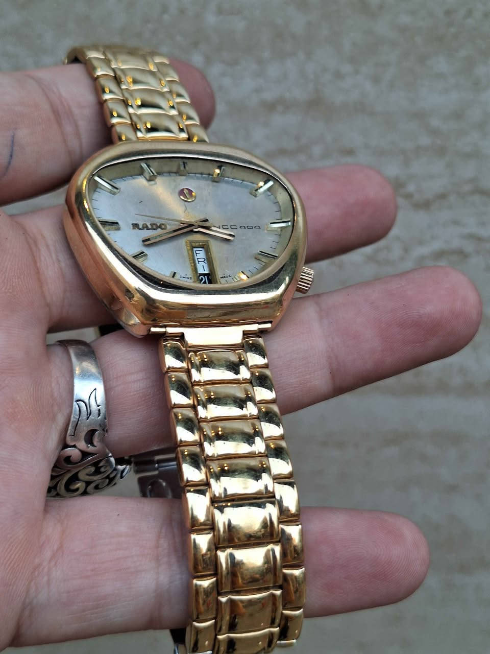 ساعة Rado NCC 404 السويسرية الكلاسيكية، والمعروفة بين الهواة والمجمعين باسم "Rado Cobra" نظراً لشكل هيكلها الفريد غير المتماثل الذي يشبه رأس أفعى الكوبرا.تنتمي هذه الساعة إلى سلسلة "NCC" (اختصار لـ New Case Concept) التي أطلقتها شركة رادو السويسرية في أواخر الستينيات وبداية السبعينيات لتجربة تصاميم وهياكل هندسية مبتكرة ومقاومة للصدمات والماء بشكل متطور في وقتها.أبرز مواصفات ومميزات الساعة:التصميم والهيكل: تأتي بهيكل فريد ومطلي بالذهب. يتميز التصميم بغياب العروات التقليدية (Lugs) مما يجعلها مريحة جداً على المعصم رغم حجمها البارز.المينا (Dial): باللون الفضي/الذهبي الفاتح مع مؤشرات بارزة ثلاثية الأبعاد (Baton Indices) وعقارب ذهبية متناسقة.نافذة التاريخ: تتميز بنافذة رأسية فريدة لعرض اليوم والتاريخ معاً عند مؤشر الساعة 6.شعار المرساة (Anchor Logo): يتوسط المينا تحت مؤشر الساعة 12 شعار رادو الشهير "المرساة المتحركة".الحركة: تعمل بحركة ميكانيكية أوتوماتيكية (سويسرية الصنع) معتمدة على الاهتزاز والتحرك الذاتي. مركز طوخ, القليوبية


**إذا كنت صاحب هذا الإعلان وتريد حذفه لأي سبب، رجاءا أرسل رسالة إلى الدعم الفني**