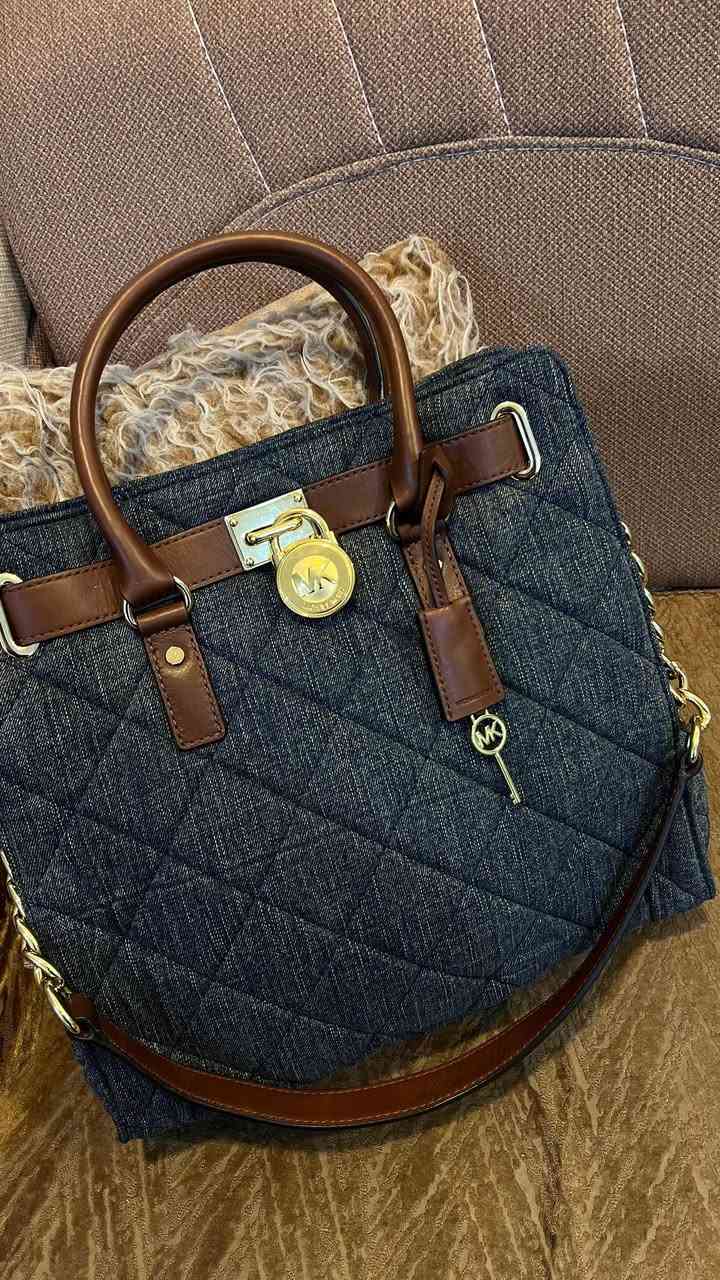 حقيبة مايكل كورس هاملتون هي حقيبة يد ساتشل/توت (Satchel/Tote) من تصميم العلامة التجارية Michael Kors. تتميز هذه النسخة بتصميمها المصنوع من قماش الجينز المبطن (Quilted Denim) باللون الأزرق مع مقابض وحواف من الجلد باللون البني

الميزات: تتميز الحقيبة بقفل معدني كلاسيكي يحمل شعار الماركة على الجهة الأمامية، وحمالات يد علوية، بالإضافة إلى حزام كتف قابل للتعديل والفصل مصنوع جزئيًا من سلسلة معدنية ذهبية اللون.

الحقيبة عملية ومرتبة، تسع الأغراض الأساسية اليومية بكل أناقة.
قطعة نادرة وغير متوفرة بكثرة، تناسب محبات القطع المختلفة والستايل الكلاسيكي العصري.
الحالة: ممتازة ✨
ا
القطعة ختم وكود
للتواصل خاص. :*********** واتساب فقط
