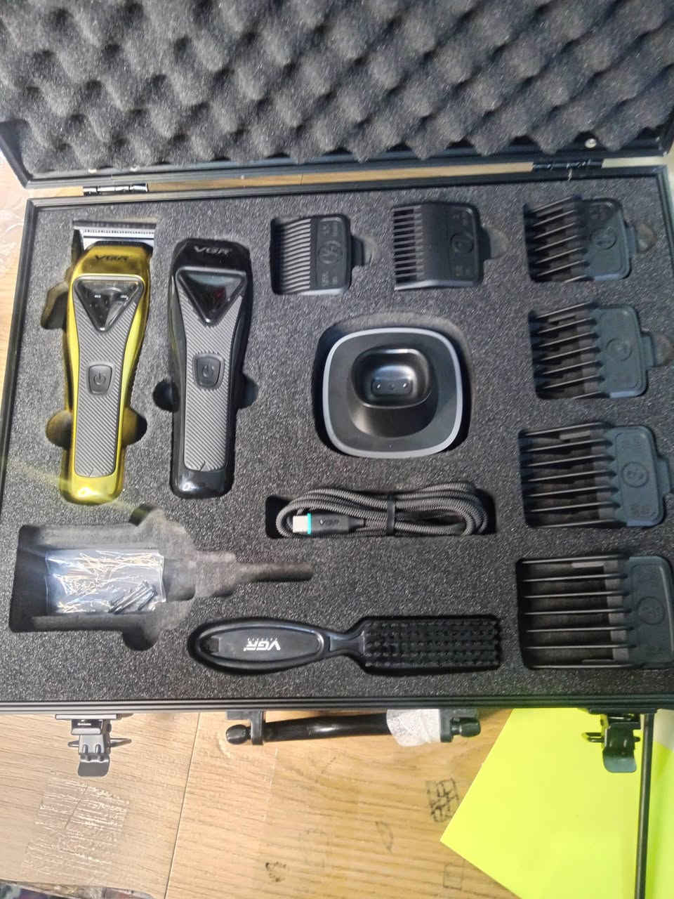 تُعد هذه المجموعة ماكينة حلاقة احترافية من VGR طراز V-015. تتميز بتصميم معدني قوي وتأتي مع محرك فيكتور قوي يوفر سرعة تصل إلى 9000 دورة في الدقيقة.
الميزات والمواصفات:
الشفرات: شفرات متينة مطلية بـ DLC (طلاء كربون يشبه الألماس).
المحرك: محرك فيكتور قوي 9000 دورة في الدقيقة.
البطارية ووقت التشغيل: بطارية ليثيوم أيون بسعة 2500 مللي أمبير توفر ما يصل إلى 120 دقيقة من وقت التشغيل بعد شحنها بالكامل لمدة 3 ساعات.
الاستخدام: تدعم الاستخدام السلكي واللاسلكي Cord/Cordless.
الملحقات: تتضمن 6 أمشاط توجيه مغناطيسية بأطوال مختلفة (1.5، 3، 4.5، 6، 10، 13 ملم)، وفرشاة تنظيف، وزيت تشحيم، وكابل شحن USB، وحقيبة سفر.
التصميم: هيكل معدني بتصميم أنيق بلون ذهبي وأسود، مع رافعة مدببة قابلة للتعديل.  رقمي***********
