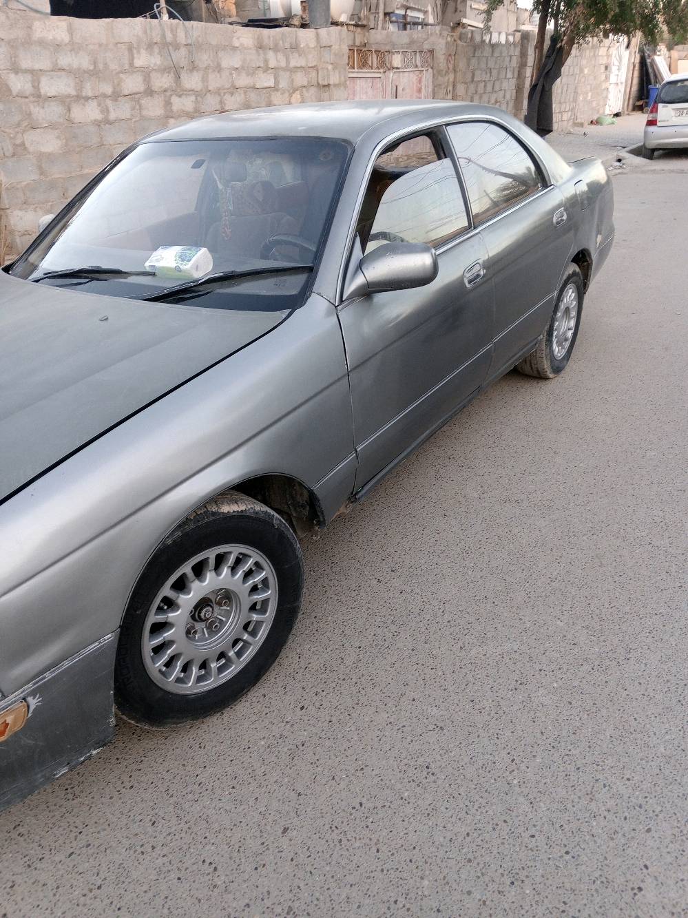 السيارة المعروضة للبيع هي من نوع تويوتا موديل قديم. لون السيارة رمادي ومظهرها العام نظيف وجاهزة للاستخدام. تحتوي السيارة على مقاعد قماشية ولوحة قيادة عملية مع مقود مغطى.

السيارة ذات ناقل حركة أوتوماتيك وتتوفر فيها العديد من المزايا التقليدية لهذه الفئة العمرية. تعد خياراً اقتصادياً لمن يبحث عن سيارة مستعملة تؤدي الغرض بأسعار معقولة.