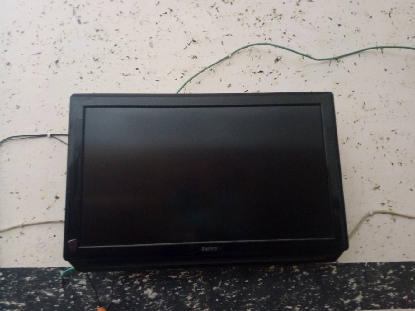 تلفزيون بلازما Sanyo للبيع، حالته جيدة ومعلق على الحائط. مناسب للمجالس أو غرفة الجلوس. الأزرار تعمل بشكل ممتاز والشاشة نظيفة.