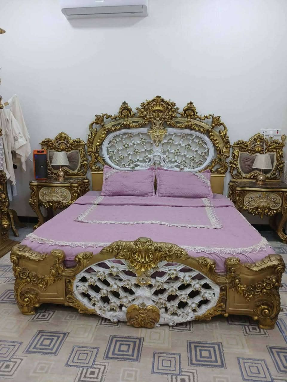 فخر الصناعة المصرية : "لعشاق الفخامة والذوق الملكي.. قطعة أثاث مميزة متوفرة الآن" التصميم: غرفة نوم موديل ملكي، تتميز بنقوش يدوية بارزة (دمياطي أو كلاسيك ثقيل) باللون الذهبي المطعم بالأبيض العاجي.
​السرير (التاج): يتميز بتاج عالٍ جداً بنقوش مفرغة وفخمة، مع تنجيد "كابيتونيه" باللون الأبيض لإعطاء راحة وشكل ملكي.
​الكنتور (الدولاب): ضخم جداً (جامب) مع مرايا جانبية ونقوش ذهبية تمتد على كامل الأبواب، مما يعطي إيحاءً بالاتساع والرقي.
​ميز التواليت: تصميم فريد بمرآة كبيرة وإطار ذهبي مزخرف، مع سطح رخامي  يضيف لمسة من الفخامة.
​الملحقات: الغرفة كاملة تشمل الكومودينات الجانبية والمقعد (البوف) الخاص بميز التواليت بنفس التصميم والنقش.
*********** وتساب السعر ١٥٠٠
