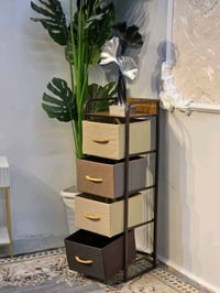 عندي كومدي خشبي عصري مكون من أربع أدراج بألوان متناسقة. التصميم أنيق و...