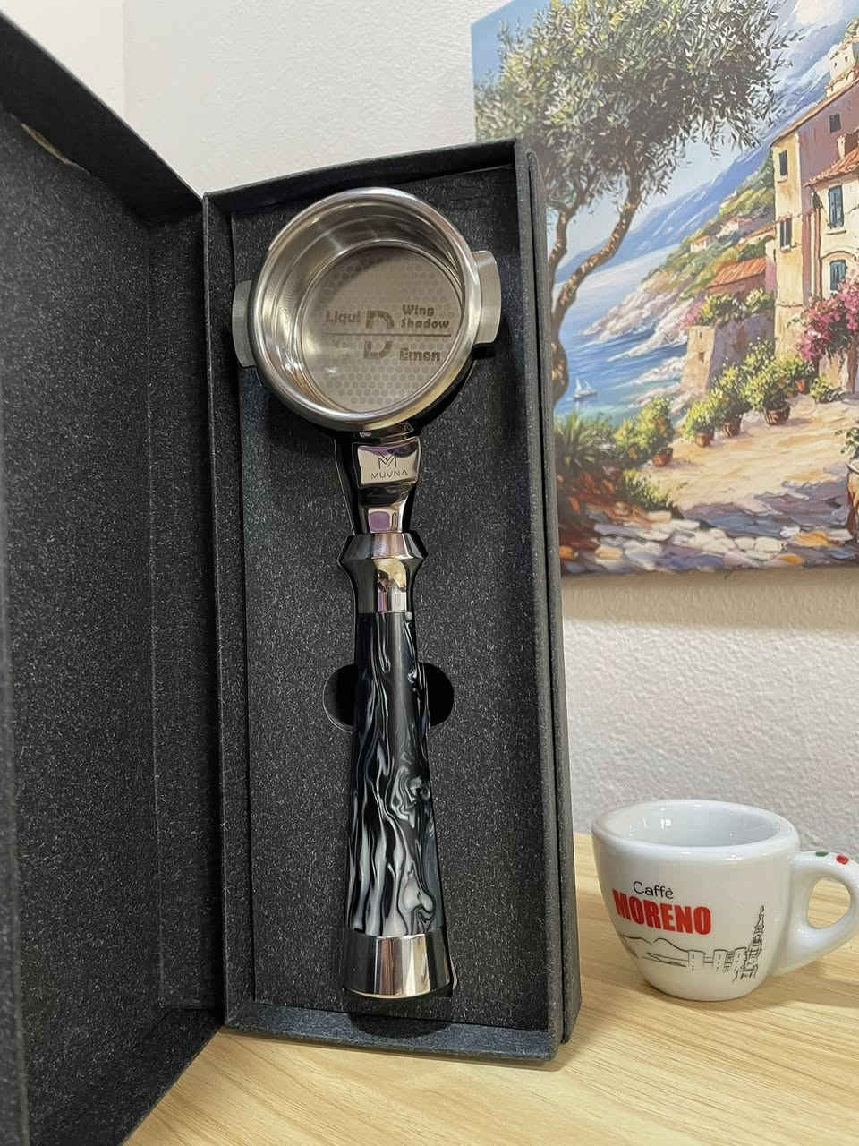 (Bottomless Portafilter) مخصص لآلات الإسبريسو الاحترافية، وهو من إنتاج شركة MUVNA المعروفة في أكسسوارات القهوة المختصة.

إليك تفاصيل ومواصفات هذه القطعة بناءً على الصور:
1. التصميم والمظهر
 المقبض (Handle): يأتي بتصميم مميز جداً بنقشة رخامية متموجة باللونين الأسود والأبيض (Resin/Acrylic swirl)، مع نهايات معدنية مصقولة من الكروم اللامع تعطي ثقلاً وتوازناً أثناء الاستخدام.

 الرأس (Head): مصنوع من المعدن المقاوم للصدأ (Stainless Steel) عالي الجودة والمصقول بعناية.
 العلامة التجارية: شعار MUVNA محفور بوضوح على الجزء المعدني الواصل بين المقبض والرأس.

2. السلة (Basket) المرفقة
 البورتافلتر يأتي ومعه سلة ترشيح احترافية مدمجة.
 تسمى هذه السلة في هذا الإصدار بـ "Liquid Demon" أو "Wing Shadow" كما هو محفور في قاع السلة داخلياً.
 تتميز السلة بنمط ثقوب دقيق جداً (توزيع متناسق يشبه خلايا النحل في الأطراف)، وهو تصميم مخصص لتحسين التدفق (High-flow) لضمان استخلاص متساوٍ لكامل كعكة القهوة (Puck) واستخراج نكهات أكثر وضوحاً وقوام غني.


**إذا كنت صاحب هذا الإعلان وتريد حذفه لأي سبب، رجاءا أرسل رسالة إلى الدعم الفني**