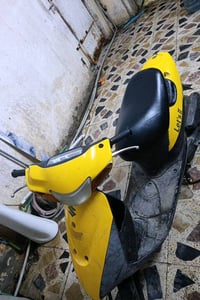 دراجة سكوتر يابانية الصنع، موديل لايتس، لونها أصفر لافت للنظر. مناسبة ...