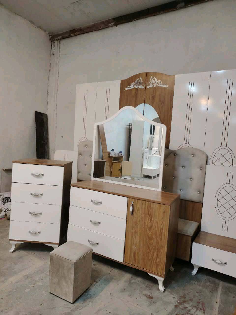 مجموعة غرفة نوم جديدة تحتوي على خزانات واسعة ومرآة وطاولة زينة مصنوعة من خشب متين. التصميم يجمع بين الأناقة والخطوط العصرية مع لمسات كلاسيكية. مثالية لإضفاء لمسة جمالية على غرفة النوم.