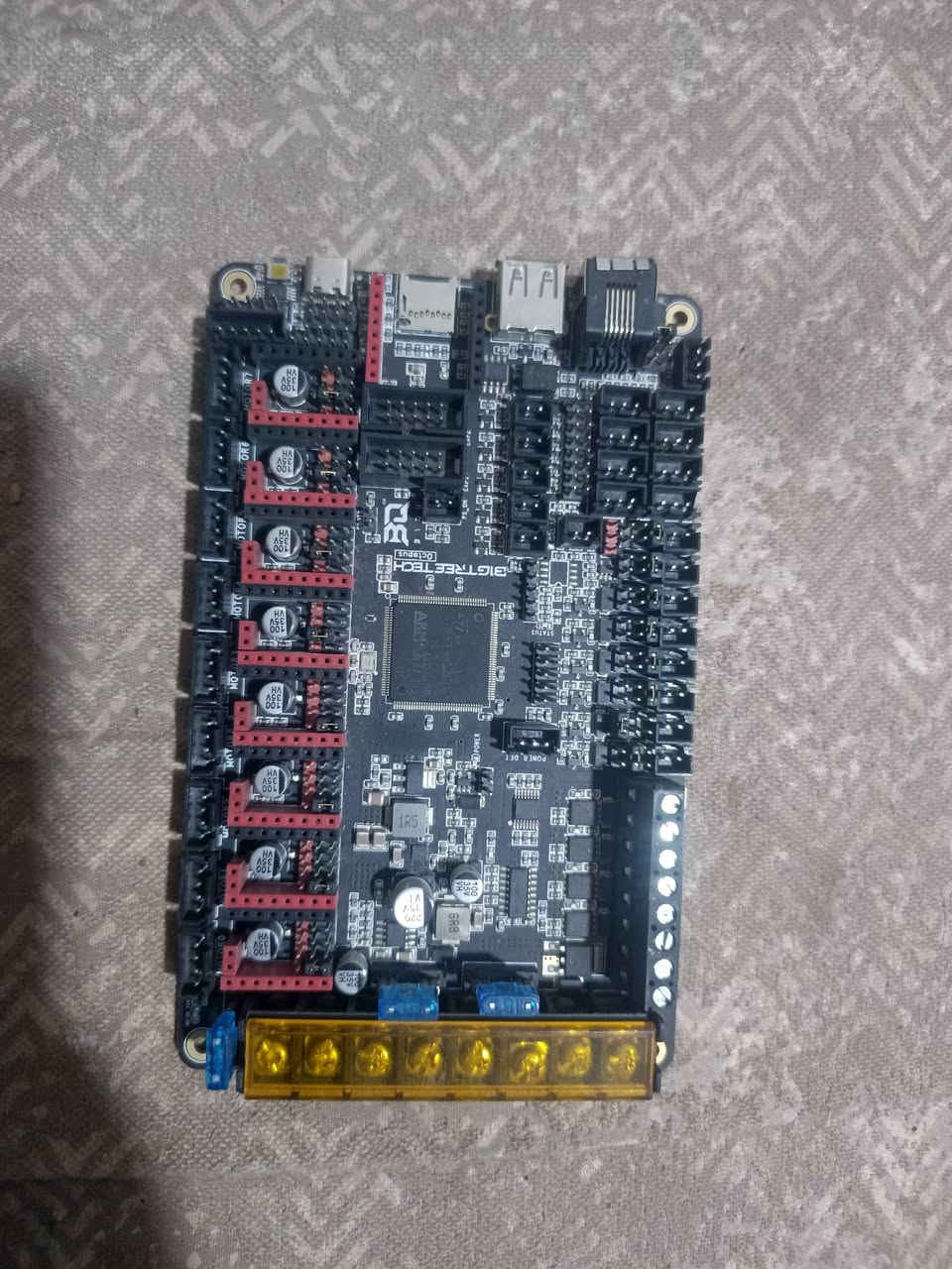 اسلام عليكمالمعالج والسرعة (MCU)
​المعالج: معالج 32-بت احترافي من نوع STM32F446ZET6 (معمارية ARM Cortex-M4).
​التردد: يعمل بسرعة 180 ميجاهرتز، مما يضمن معالجة الأوامر المعقدة وحسابات الحركة بسرعة فائقة وبدون أي تعليق.
​التحكم بالمحركات (Stepper Drivers)
​عدد المنافذ: تدعم تركيب حتى 8 دريفرات محركات مستقلة (مثل TMC2209 أو TMC2209-SPI وغيرها).
​أنماط التشغيل: تدعم تشغيل الدريفرات بأنماط الـ SPI والـ UART والـ STEP/DIR بشكل مباشر عبر تغيير "الجامبرز" (Jumpers) بدون الحاجة لتوصيل وايرات خارجية.
​منافذ الطاقة والـ Bed
​جهد التشغيل: تعمل على فولتية 12 فولت أو 24 فولت تلقائياً.
​مخرجات السخان (Heaters): تدعم حتى 4 سخانات لرؤوس الطباعة (Extruders).
​مخرج الـ Bed: يدعم تيار عالي جداً لتسخين سطح الطابعة بسرعة وأمان.
​منظومة التبريد والمراوح (Fans)
​عدد منافذ المراوح: تحتوي على 6 منافذ مراوح من نوع CNC (يمكن التحكم بسرعتها عبر الـ PWM).
​منافذ إضافية: تحتوي على منفذين (2) يعملان بشكل مستمر وبأقصى طاقة.
​ميزة التحكم بالجهد: يمكنك تحديد جهد كل مروحة بشكل مستقل تماماً (سواء 5 فولت، 12 فولت، أو 24 فولت) عن طريق تغيير "الجامبر" الخاص بكل منفذ.
​الحساسات والتوصيل (Interfaces & Sensors)
​المنافذ الرقمية: منفذ USB-C للتوصيل بالكمبيوتر أو الراسبيري باي، ومنفذ لكارت الذاكرة MicroSD.
​اتصال الماكينة: دعم منفذ CAN Bus المتقدم لتقليل وايرات رأس الطابعة وتسهيل التوصيل.
​حساسات الحرارة: تدعم حتى 5 حساسات حرارة (Thermistors).
​الحساسات الإضافية: منافذ مخصصة لحساس تسوية السطح التلقائي (BLTouch / 3D Touch)، وحساسات نفاد الفيلّمنت (Filament Runout)، ومفاتيح نهاية الشوط (Endstops).
​إضافات اختيارية: منفذ مخصص لتوصيل شاشات LCD (مثل شاشات الـ RepRap أو شاشات اللمس) ومنفذ مخصص لتركيب قطعة واي فاي (مثل ESP8266).
​الأنظمة المتوافقة (Firmware)
​متوافقة بالكامل وتدعم الأنظمة الحديثة والقوية: Klipper، و Marlin، و RepRapFirmware (RRF).


**إذا كنت صاحب هذا الإعلان وتريد حذفه لأي سبب، رجاءا أرسل رسالة إلى الدعم الفني**