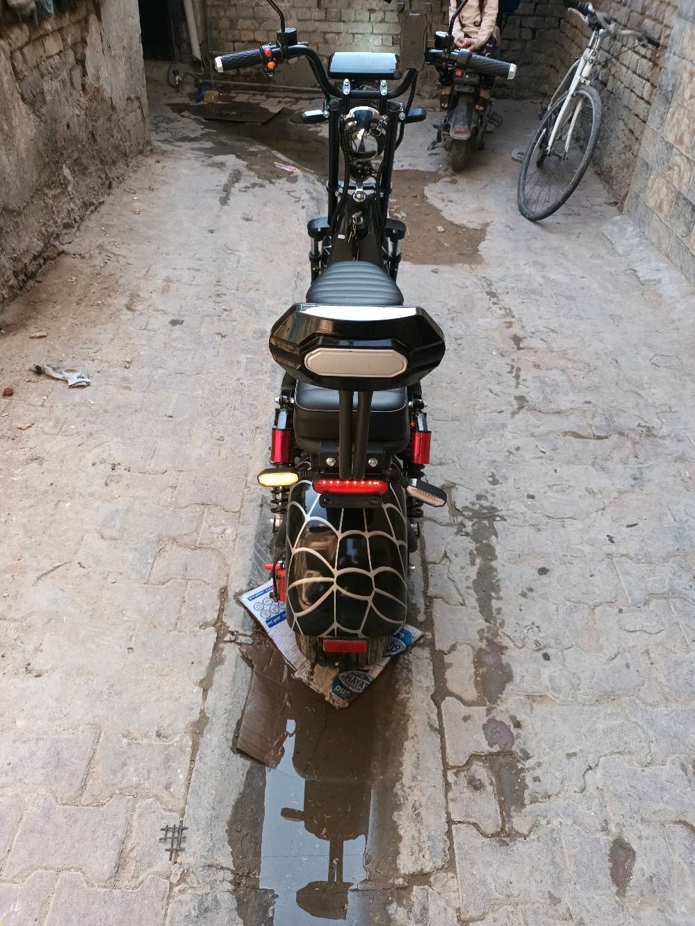 ماطور كهربائي جديد وحديث التصميم بهيكل قوي وعجلات عريضة تعطي استقرار وثبات. يحتوي على مقعدين مريحين ومُصمم بتفاصيل مميزة بنمط يشبه شبكة العنكبوت على العجلات. مثالي للتنقل السريع والبيئي داخل المدينة.