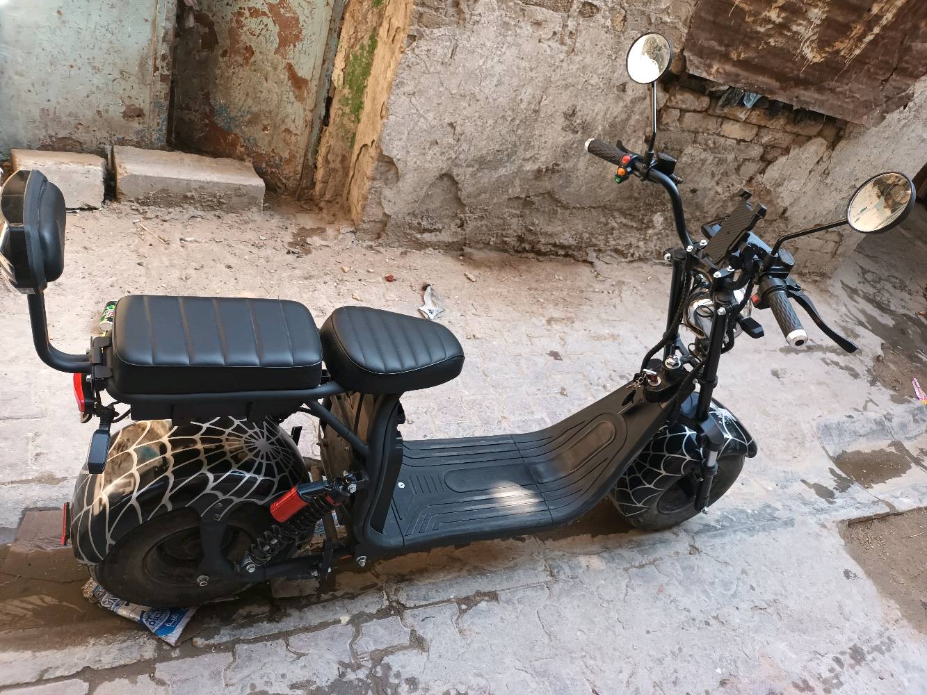 ماطور كهربائي جديد وحديث التصميم بهيكل قوي وعجلات عريضة تعطي استقرار وثبات. يحتوي على مقعدين مريحين ومُصمم بتفاصيل مميزة بنمط يشبه شبكة العنكبوت على العجلات. مثالي للتنقل السريع والبيئي داخل المدينة.