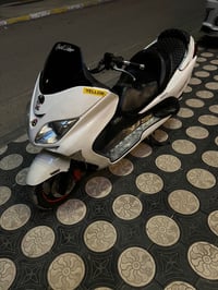 دراجة نارية سريعة وأنيقة بمحرك قوي وتصميم جذاب. لون الدراجة أبيض وتتمت...