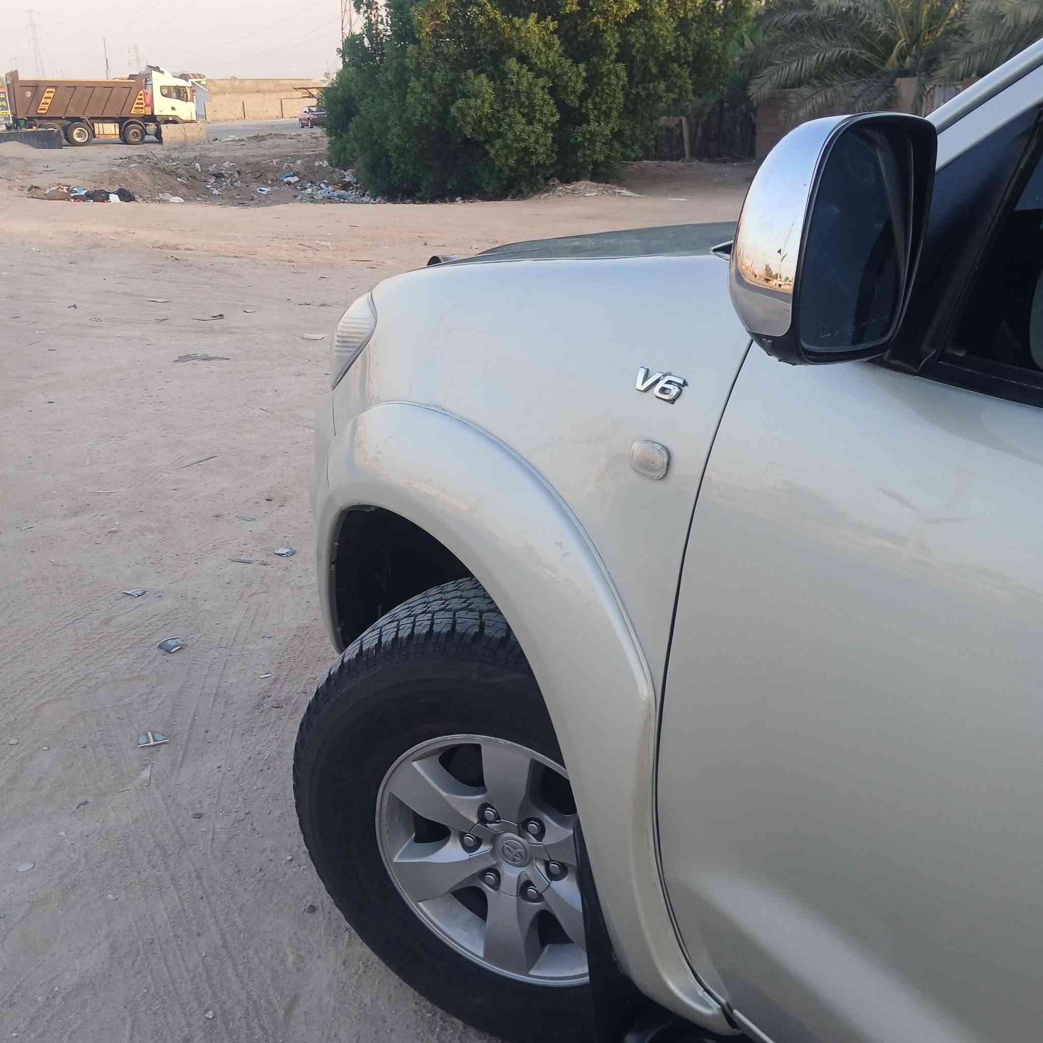 السيارة الظاهرة في الصورة "1000372575.jpg" هي تويوتا فورتشنر (Toyota Fortuner) من الجيل الأول (تحديداً الموديلات بين 2005 و 2008 قبل التحديث الأول). وهي سيارة SUV مخصصة للمهام الشاقة تعتمد على شاسيه "تويوتا هايلوكس".
إليك المواصفات الكاملة والعامة لهذا الجيل:

​1. المحرك والأداء (تأتي بخيارين رئيسيين للمحركات)

​المحرك الأول (٦ سلندر): سعة 2.7 لتر (2TR-FE) بقوة حوالي 158 حصان.

​المحرك الثاني (6 سلندر - V6): سعة 4.0 لتر (1GR-FE) بقوة حوالي 235 حصان (وهو الأكثر انتشاراً للفئات العالية).

​ناقل الحركة: آلي (أوتوماتيك) من 4 أو 5 سرعات، أو يدوي من 5 سرعات.

​نظام الدفع: دفع رباعي مستمر (4WD) مع ناقل حركة يدوي إضافي لتغيير وضعيات الدفع (الدبل الثقيل والخفيف)، وتتوفر ببعض الأسواق بدفع ثنائي خلفي فقط.

​2. الأبعاد والتصميم الخارجي

​النوع: سيارة رياضية متعددة الاستخدامات (SUV) متوسطة الحجم بـ 5 أبواب.

​المظهر الأمامي (كما في الصورة): شبك أمامي بلمسات كروم، ومصابيح أمامية هالوجين كبيرة، وكشافات ضباب سفلية مدمجة في المصد.

​الإضافات الظاهرة في الصورة: تم تركيب مصد حماية أمامي معدني (دعامية) لحماية الواجهة، وقضبان سقفية (Roof Rails).

​3. المقصورة والراحة الداخلية

​السعة: تتسع لـ 7 ركاب (ثلاثة صفوف من المقاعد).

​التكييف: نظام تكييف قوي جداً (هوائي مزدوج أمامي وخلفي لتغطية الصفوف الثلاثة).

​المقاعد: مخمل (قماش) في الفئات القياسية، وجلد في الفئات الكاملة (المواصفات العالية).

​4. الأمان والسلامة

​وسائد هوائية أمامية (Airbags) للسائق والراكب الأمامي.

​نظام فرامل مانع للانغلاق (ABS).

​هيكل صلب مخصص للطرق الوعرة وتحمل الصدمات.

​هل تود معرفة تفاصيل محددة حول فئة معينة من هذا الموديل أو قطع الغيار الخاصة به؟

السيارة الظاهرة في الصورة "1000372575.jpg" هي تويوتا فورتشنر (Toyota Fortuner) من الجيل الأول (تحديداً الموديلات بين 2005 و 2008 قبل التحديث الأول). وهي سيارة SUV مخصصة للمهام الشاقة تعتمد على شاسيه "تويوتا هايلوكس".
***********
السعر المطلوب ١٣٧٠٠٠ الف دولار مع المجال
