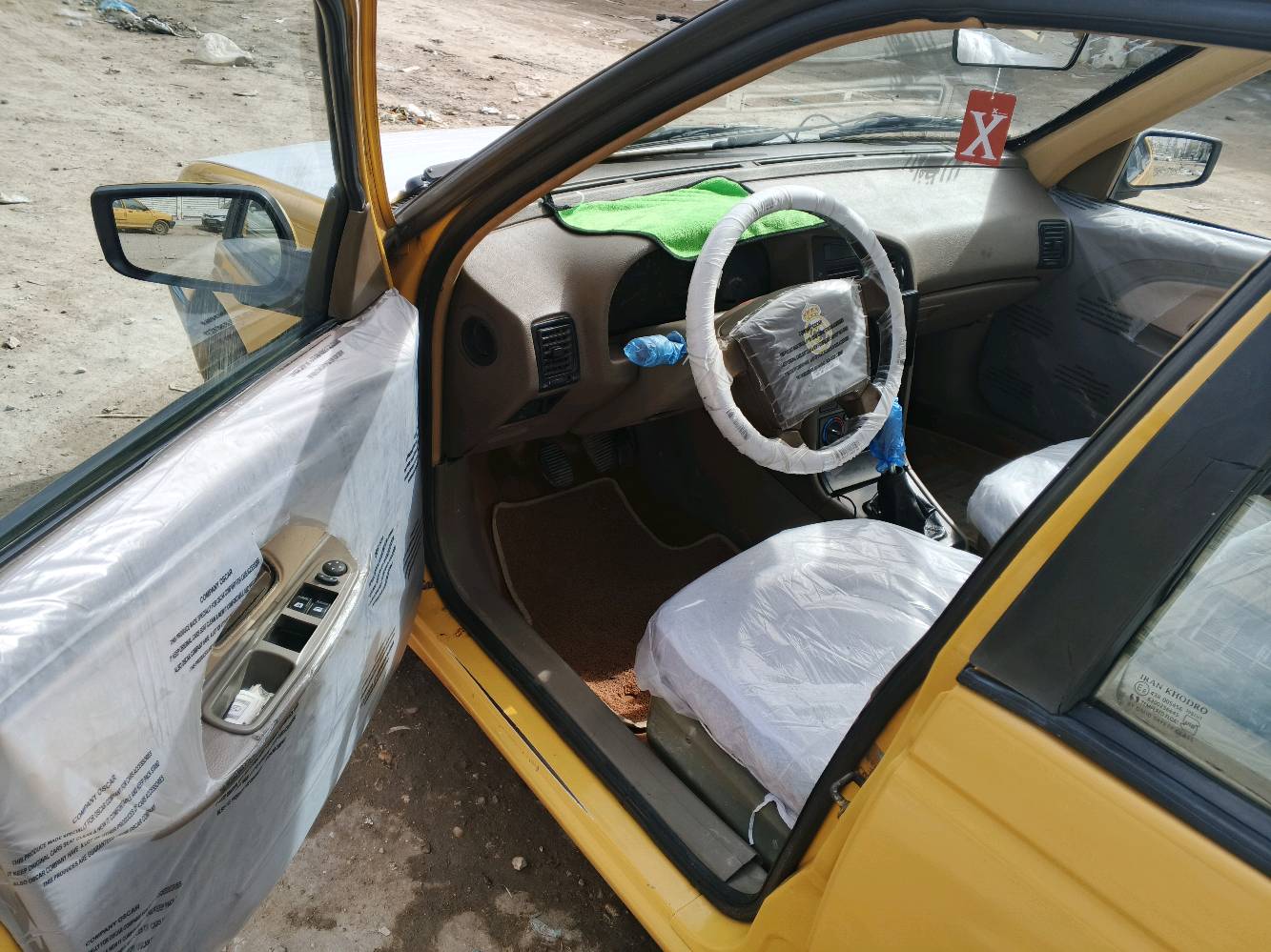 السيارة المعروضة للبيع هي بيجو بلون أصفر مع إكسسوارات زرقاء وسقف أبيض مميز. المقاعد مُغطاة بواقٍ بلاستيكي للحفاظ على النظافة، والمقود مُغطى بتغليف لضمان حماية إضافية. السيارة تبدو في حالة جيدة ولا توجد أضرار ظاهرة في الهيكل الخارجي أو الداخلي. الصندوق الخلفي واسع وكافٍ لحمل الأغراض. هذه السيارة مثالية للاستخدام اليومي أو للأعمال بفضل حالتها المحافظة والتجهيزات الأساسية المتوفرة فيها.