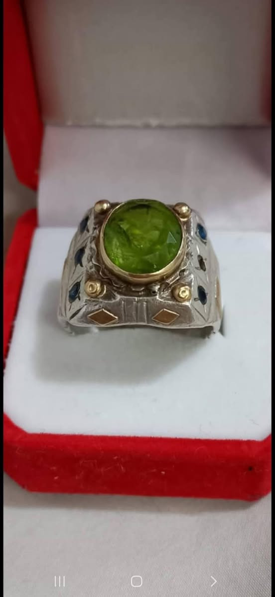 خاتم من الفضة مرصع بالذهب الخالص عيار 21 على الداير للحجر وعلى الاطراف وعلى كافة الجوانب ايضا مع احجار الزفير على جوانبه ومرصع بحجر الزبرجد الطبيعي 7 قيراط ،،،،
***********          واتساب
