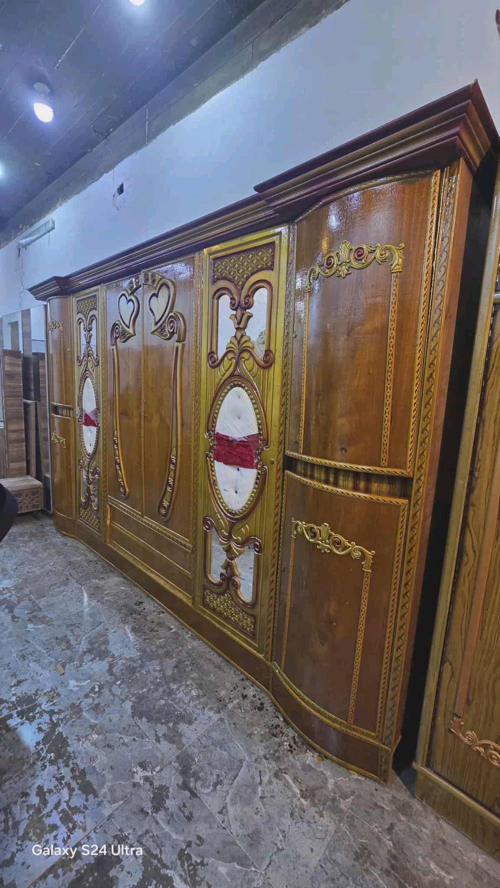 غرفة نوم فاخرة ومميزة تتضمن خزانة كبيرة مع تفاصيل زخرفية مذهلة ومرايا أنيقة. تصاميمها مستوحاة من الفن الكلاسيكي مما يضفي جمالية وجو راقي على الغرفة. الخشب ذات جودة عالية وبألوان دافئة تضيف رونق وجو من الدفء والراحة إلى أي غرفة نوم.